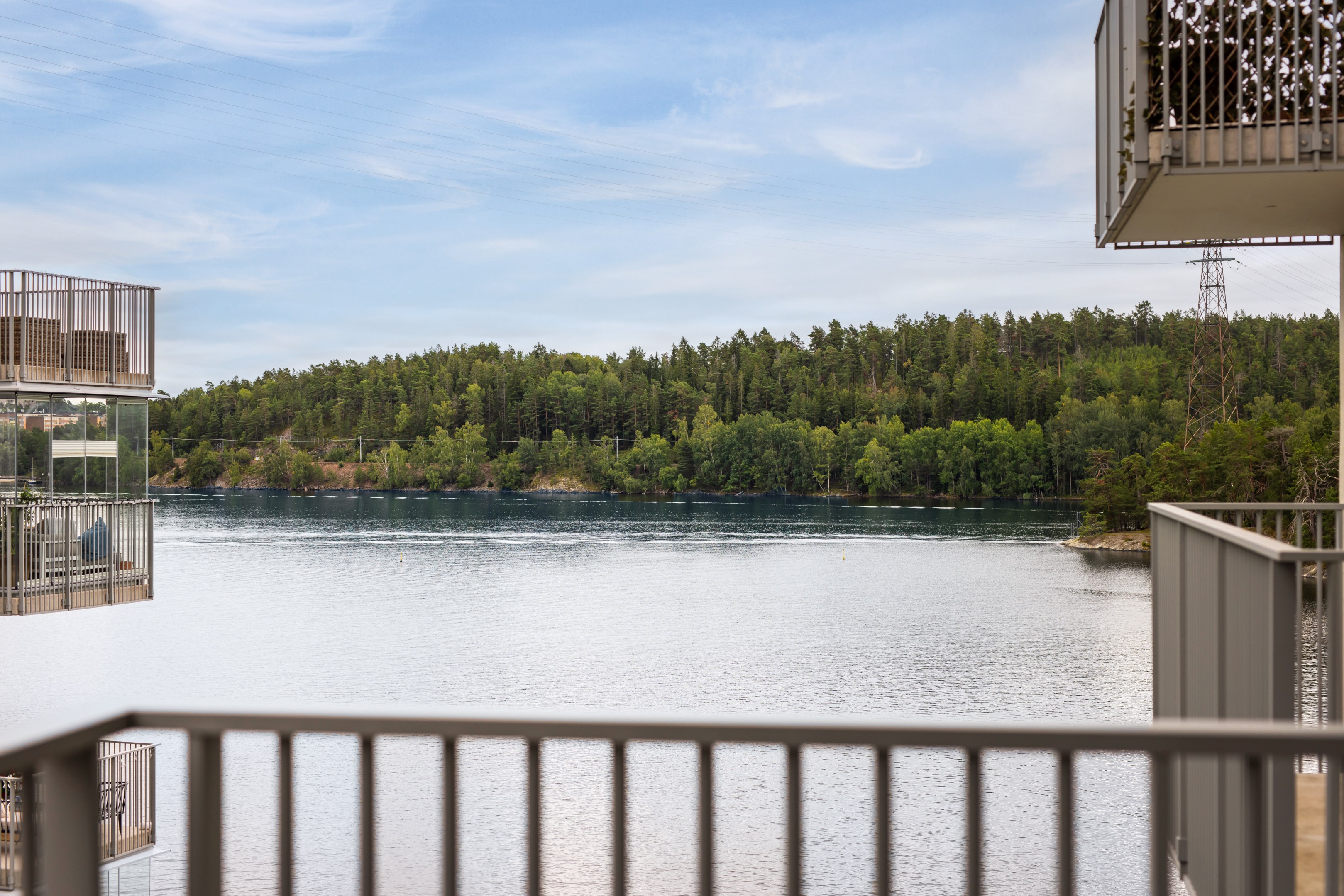 Luftig trea med balkong mot vattnet