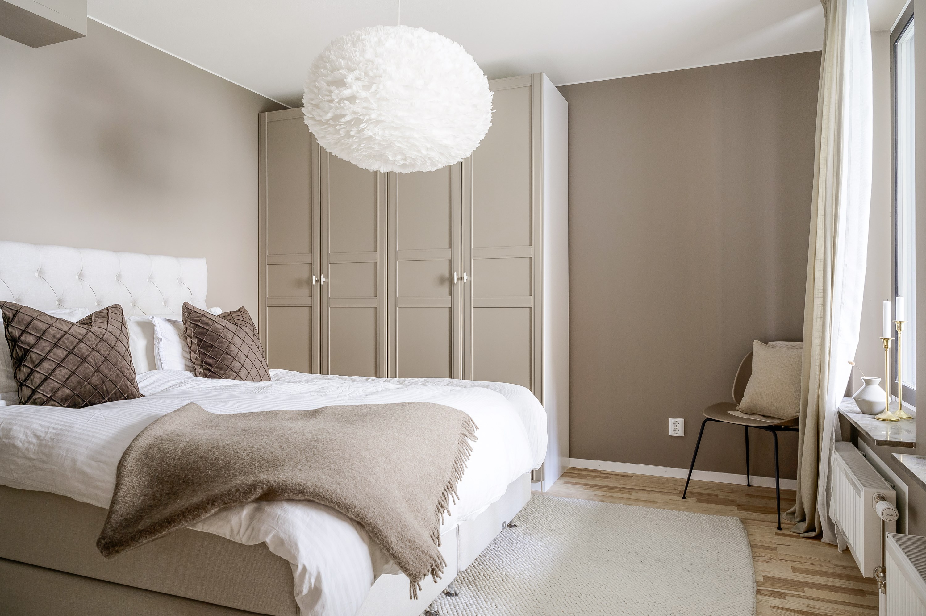 Luftigt sovrum med ljusinsläpp via balkongen.