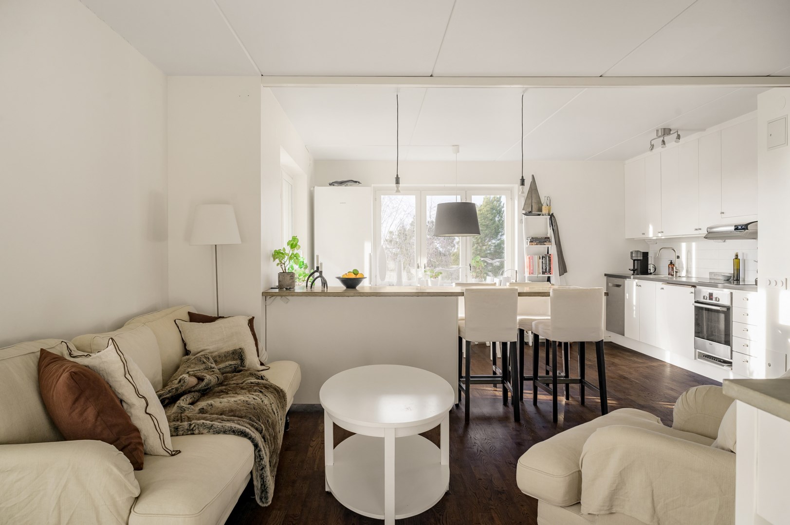 Vardagsrum med fint ljusinsläpp via köket i väster.