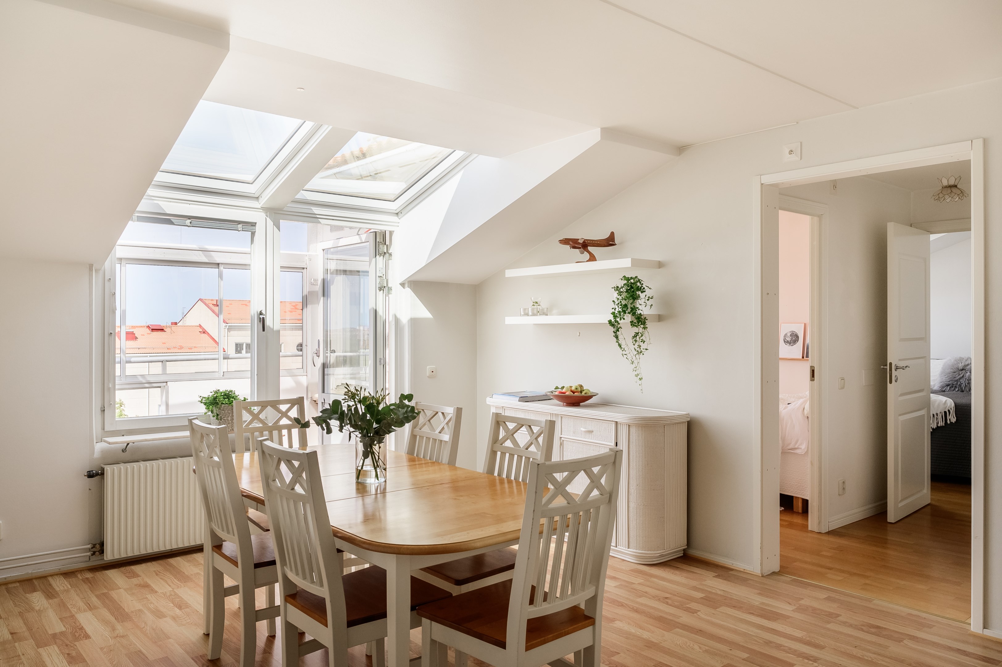 Brutna takvinklar och takfönster ger lägenheten karaktär. Till höger nås sovrum och badrum.