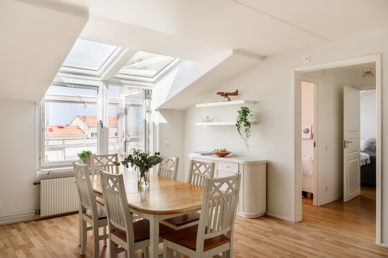 Brutna takvinklar och takfönster ger lägenheten karaktär. Till höger nås sovrum och badrum.