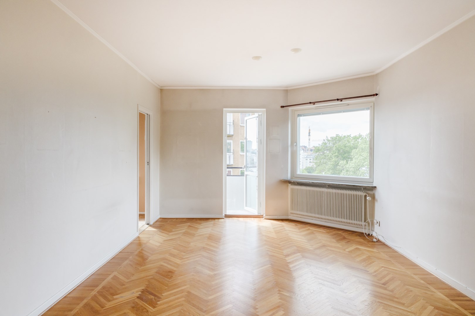 Utgång till balkong i väster. Till vänster nås kök och matplats.