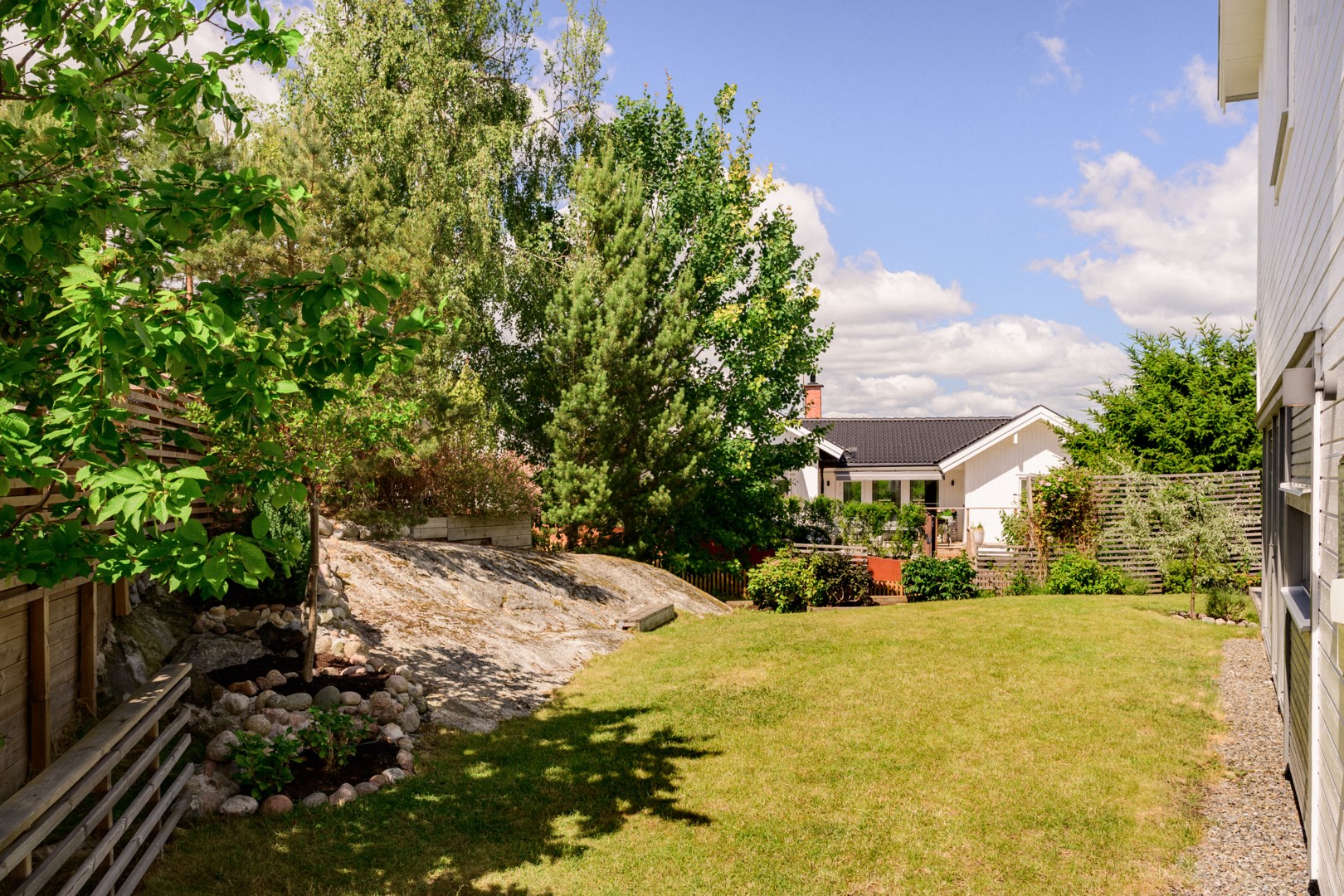 Trädgården ramas in av uppvuxen grönska.