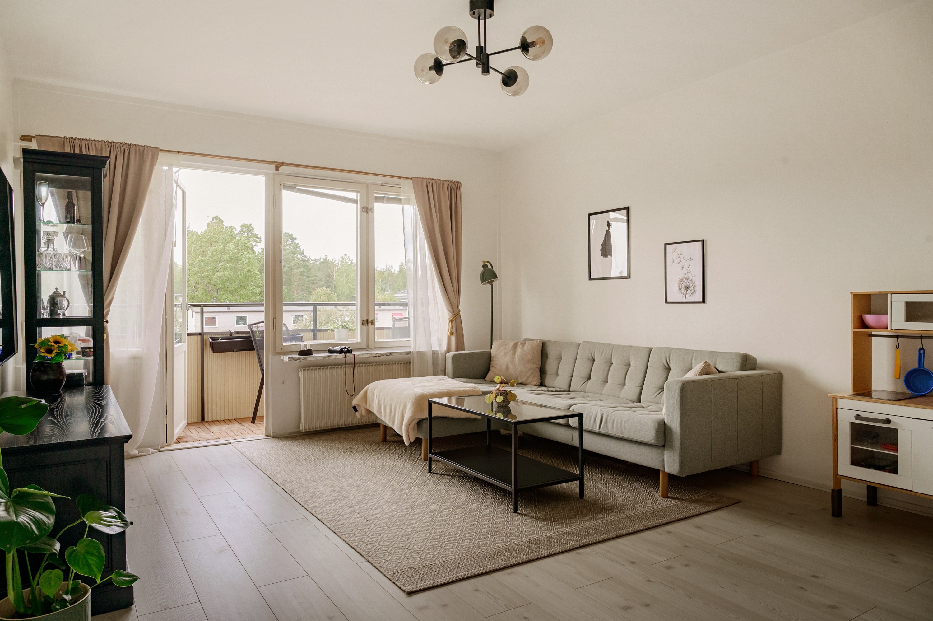 Luftigt vardagsrum med utgång till balkong i väster.