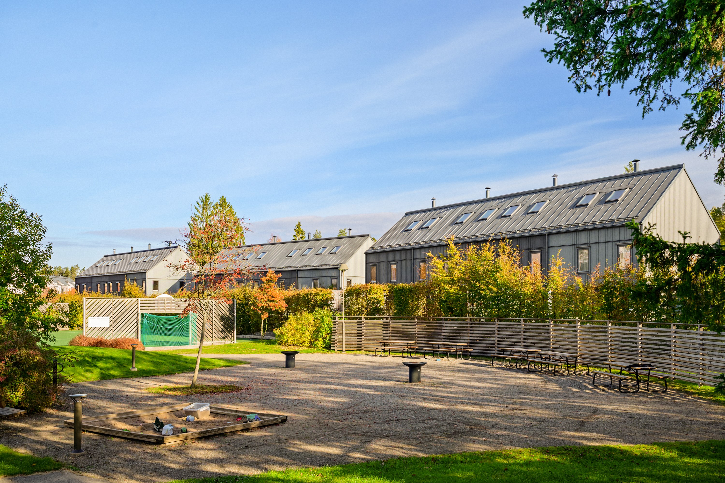 Grillplats och sittgrupper nära husets entré.