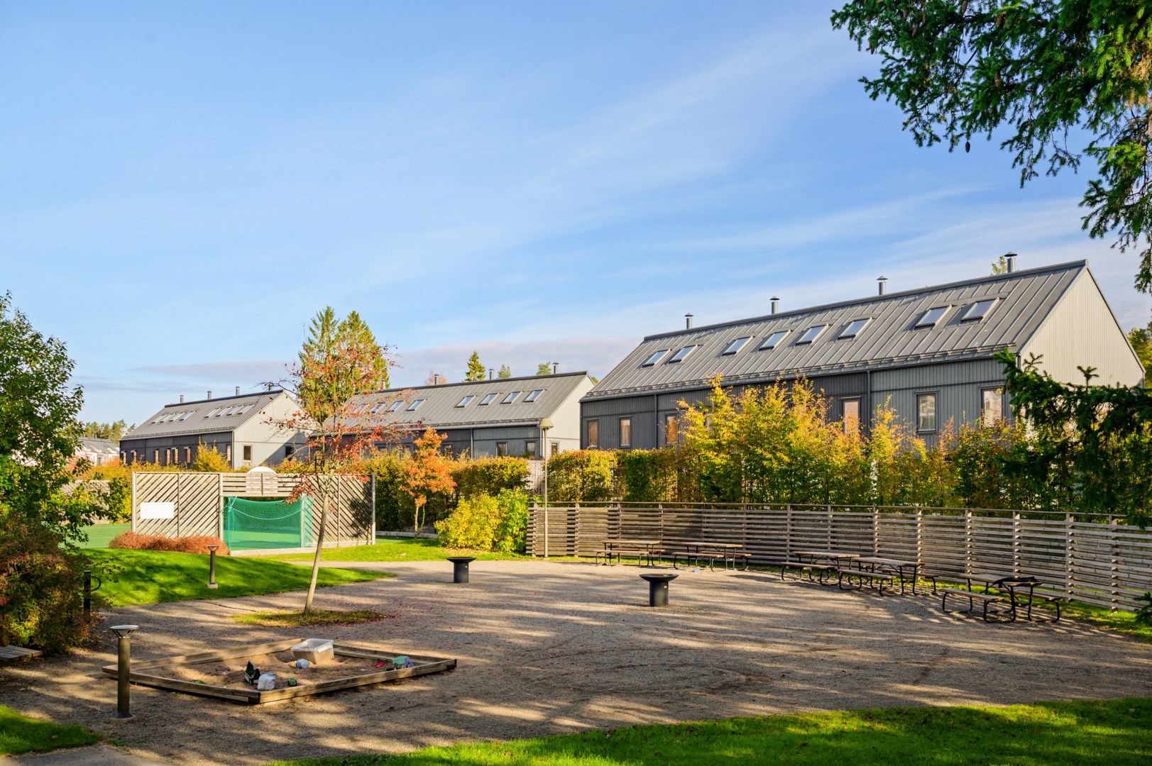 Grillplats och sittgrupper nära husets entré.