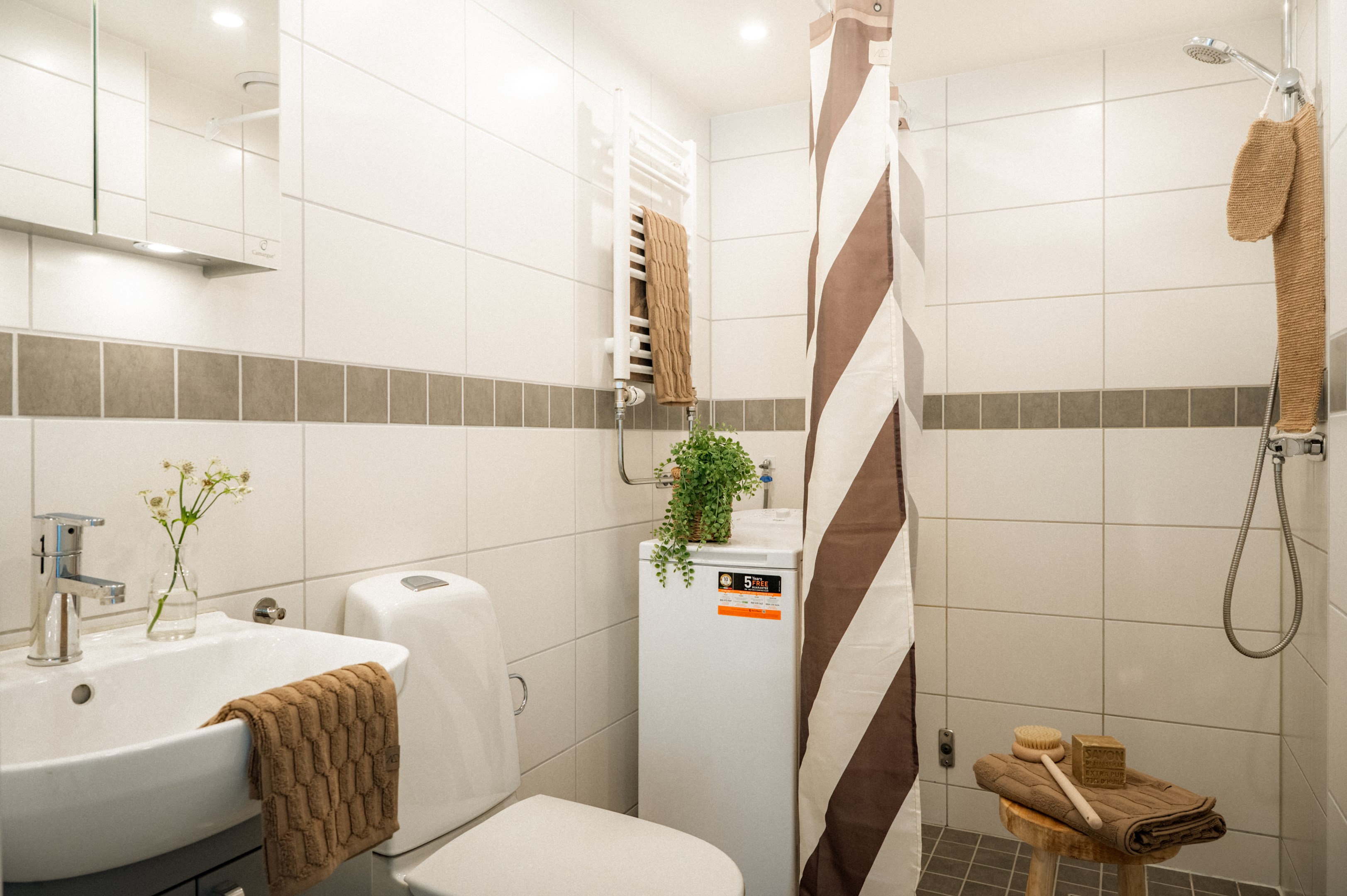 Helkaklat badrum med dusch och tvättmaskin