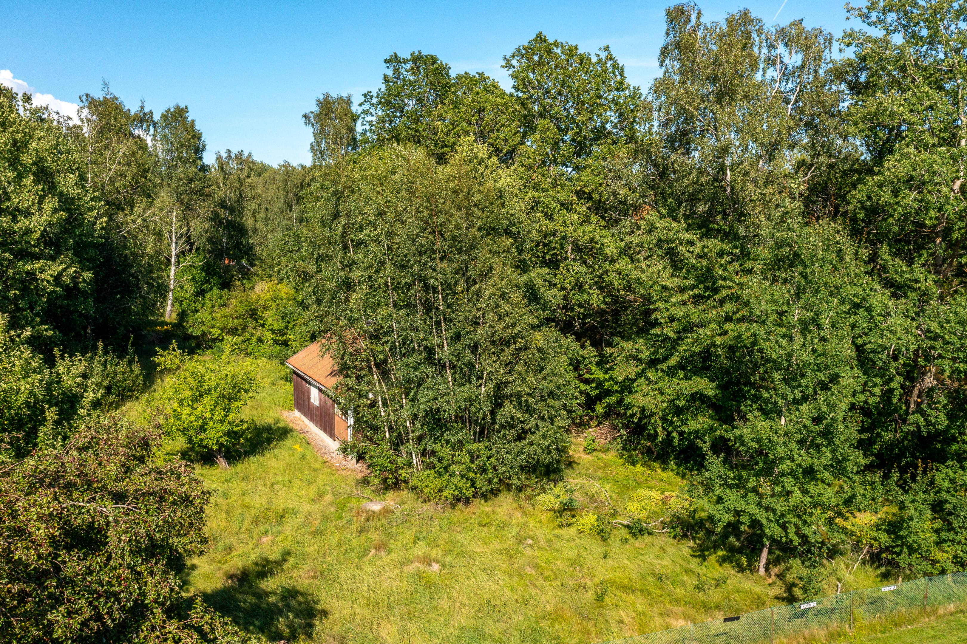 Befintligt hus med plana grönytor i söder och väster.