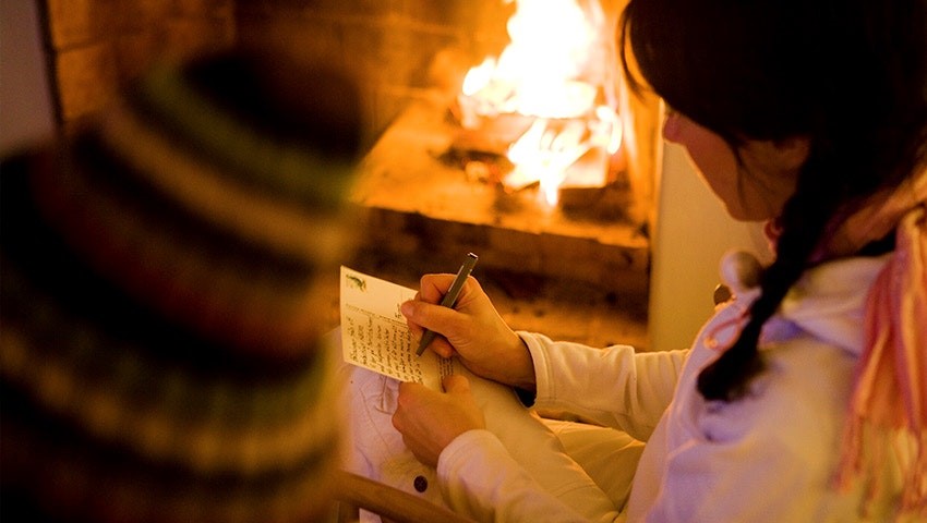 Sänder hälsning vid sprakande brasa