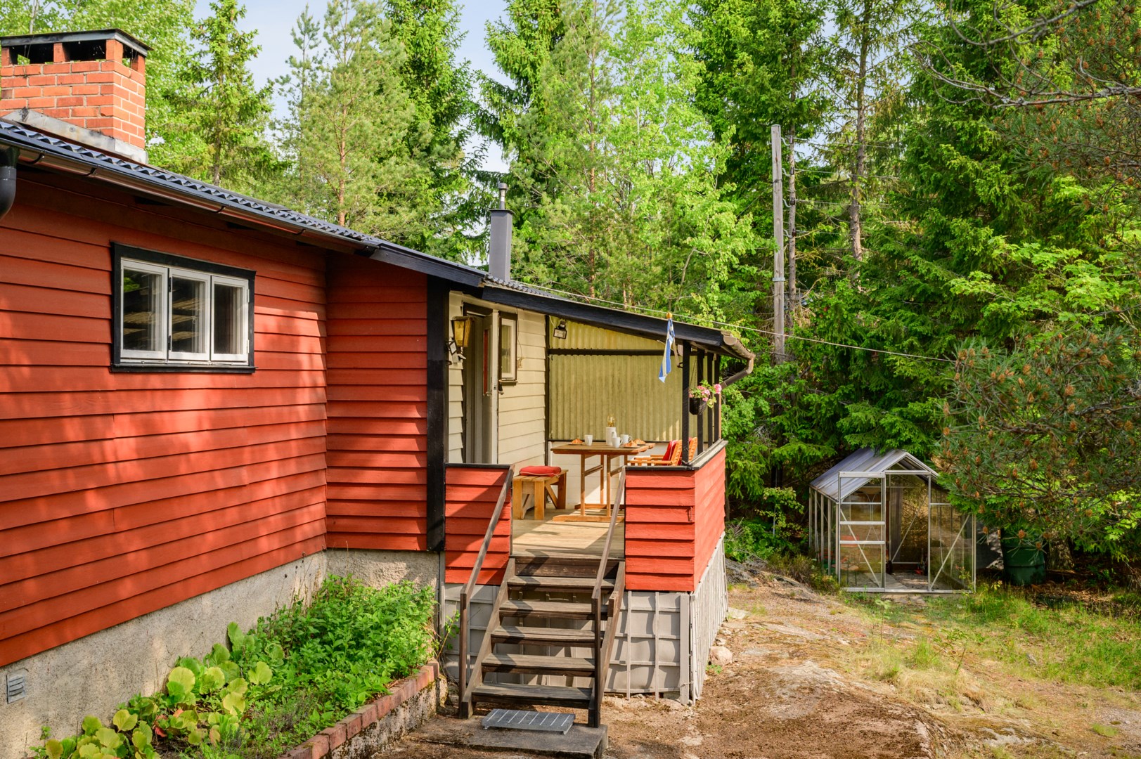 Husets entré med anslutande altan.