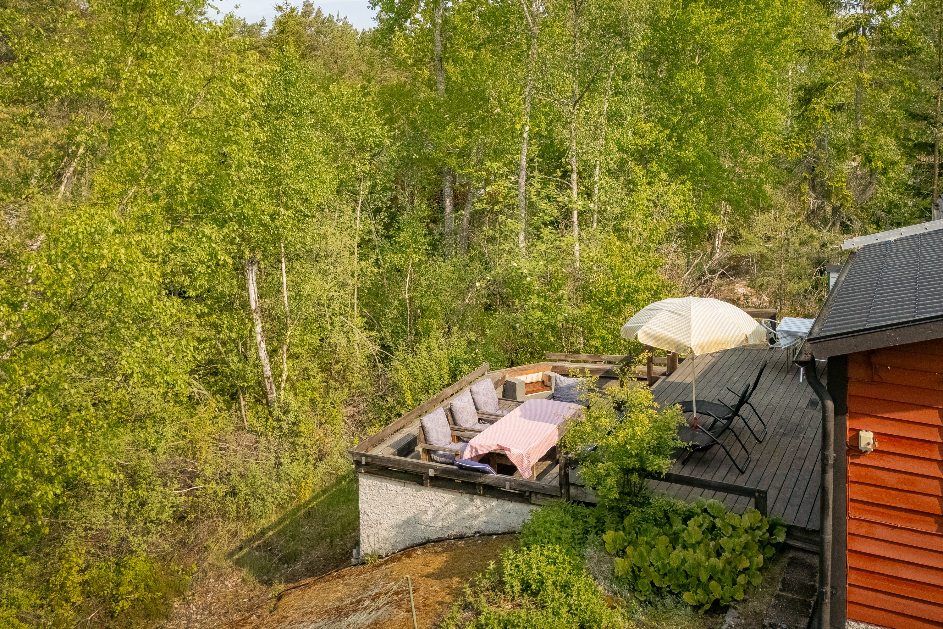 Terrassen har ett skyddat sydvästläge med utsikt över grönskan.