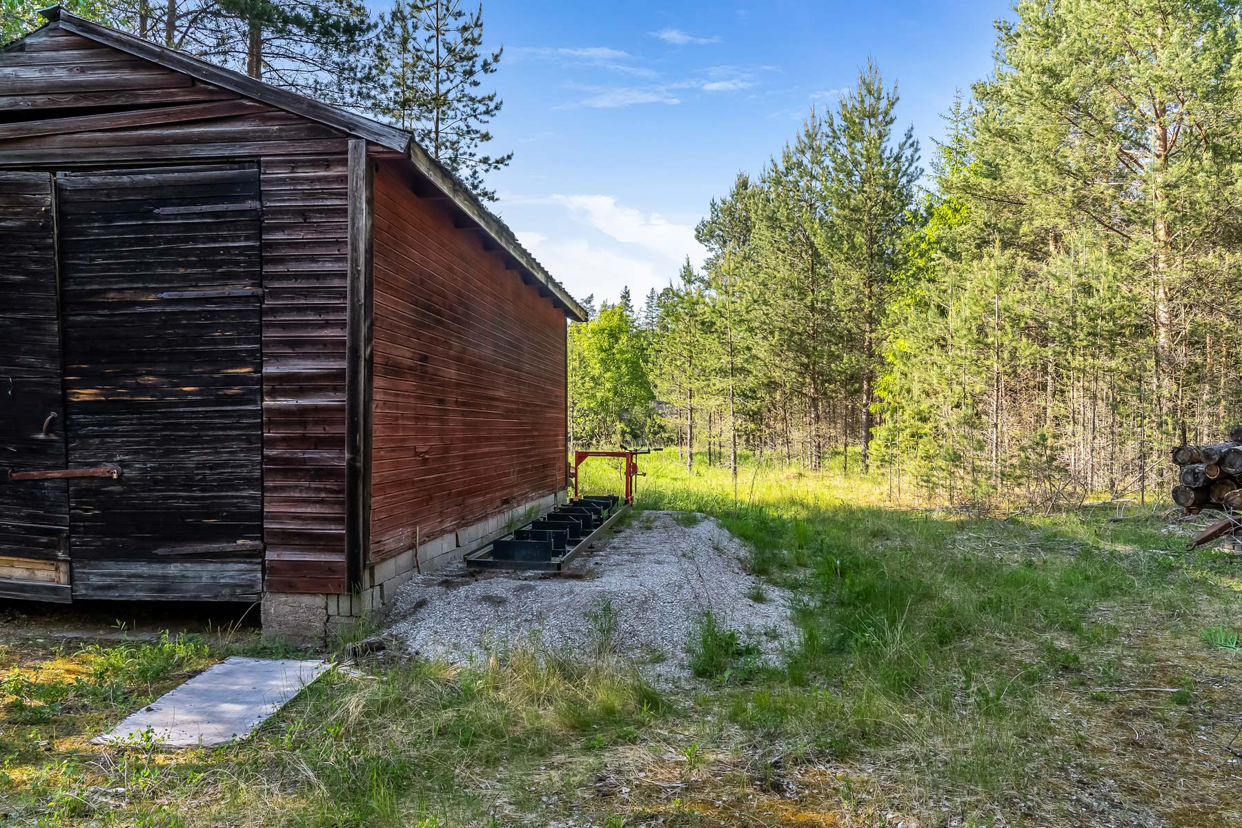 Äldre byggnad på tomten med infart från Riksvägen