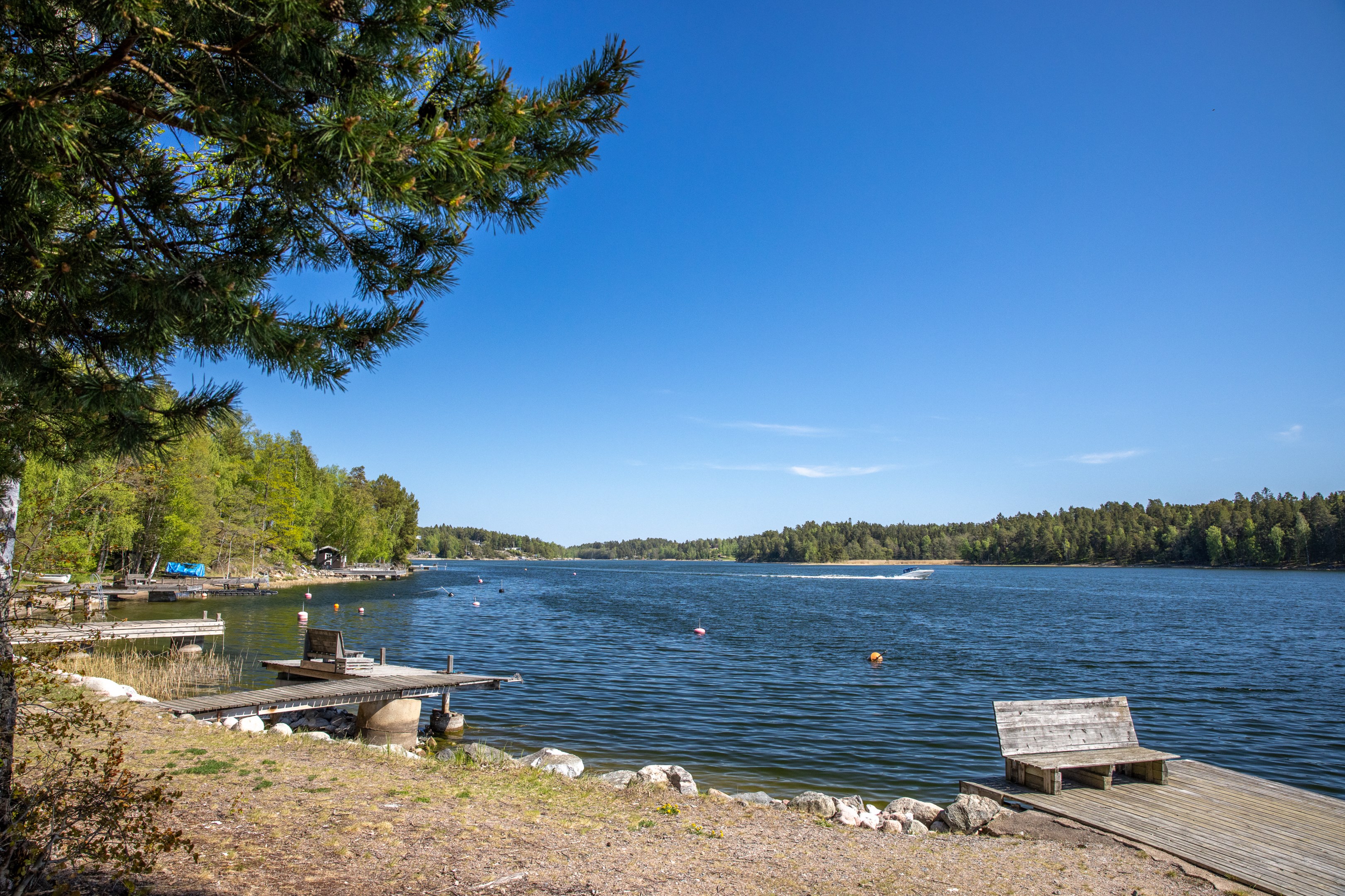 Kort promenad ned till samfälld strand och bryggor utmed Återlögafjärden