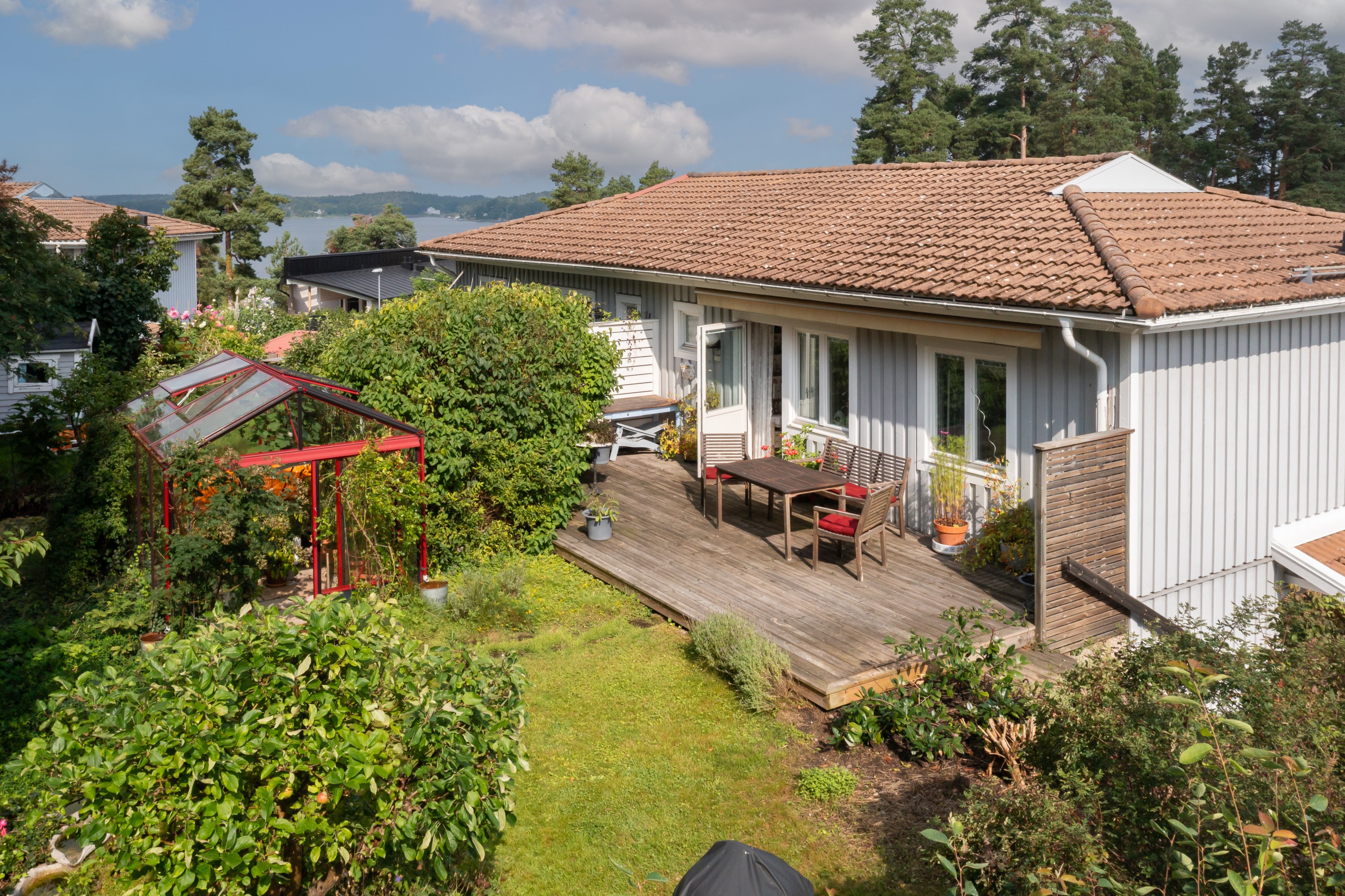 Husets lummiga baksida med altan i söderläge