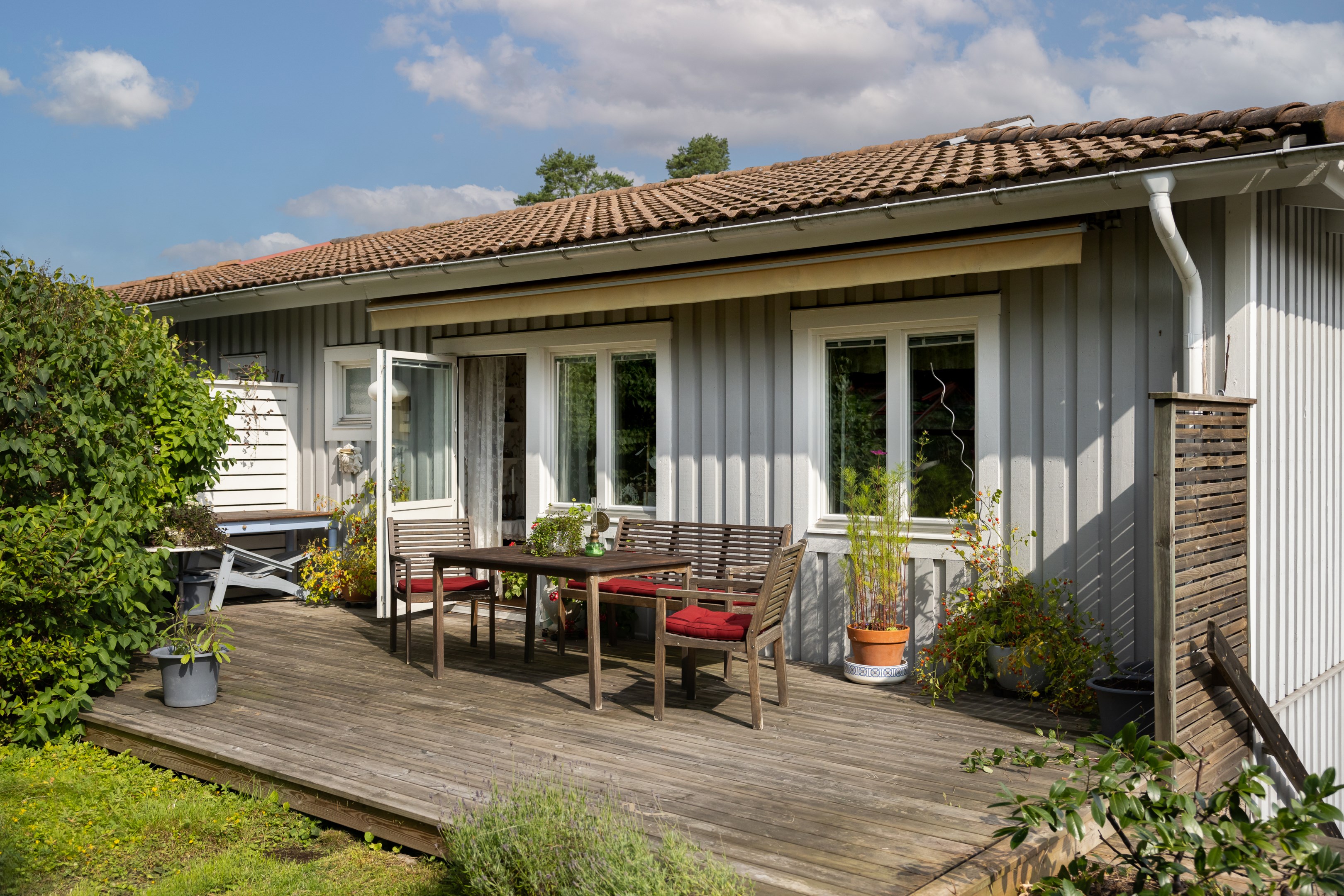 Altan i skyddat söderläge på husets lummiga baksida