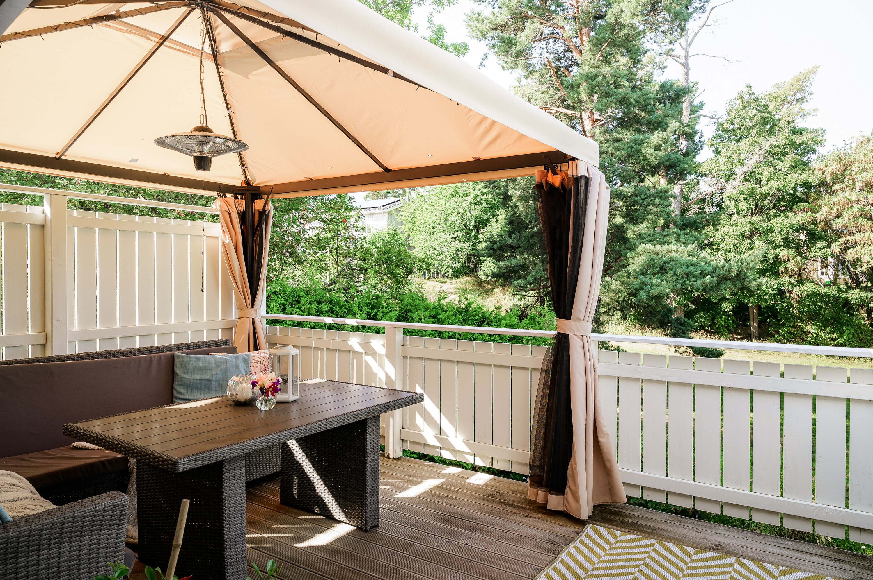 Balkong med soldränkt läge och utsikt mot grönska.