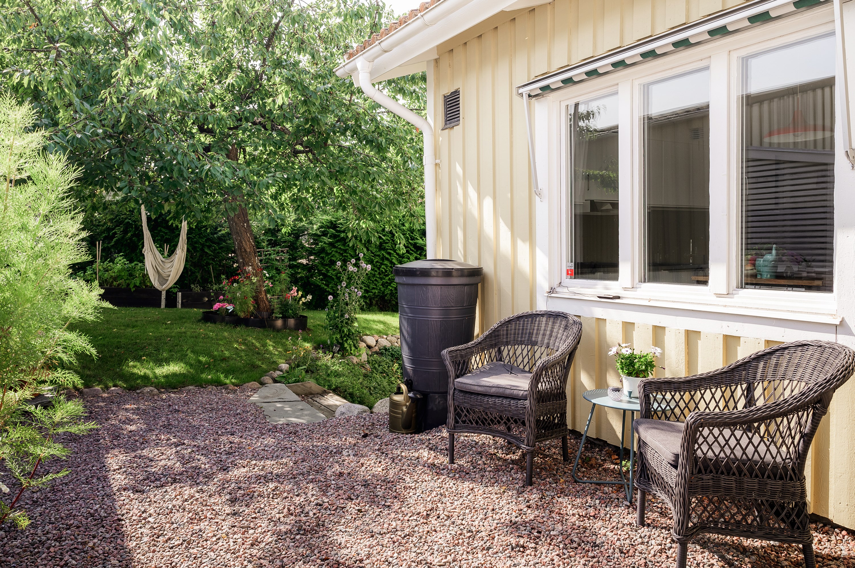 Morgonkaffet avnjuts i trädgården på husets framsida.