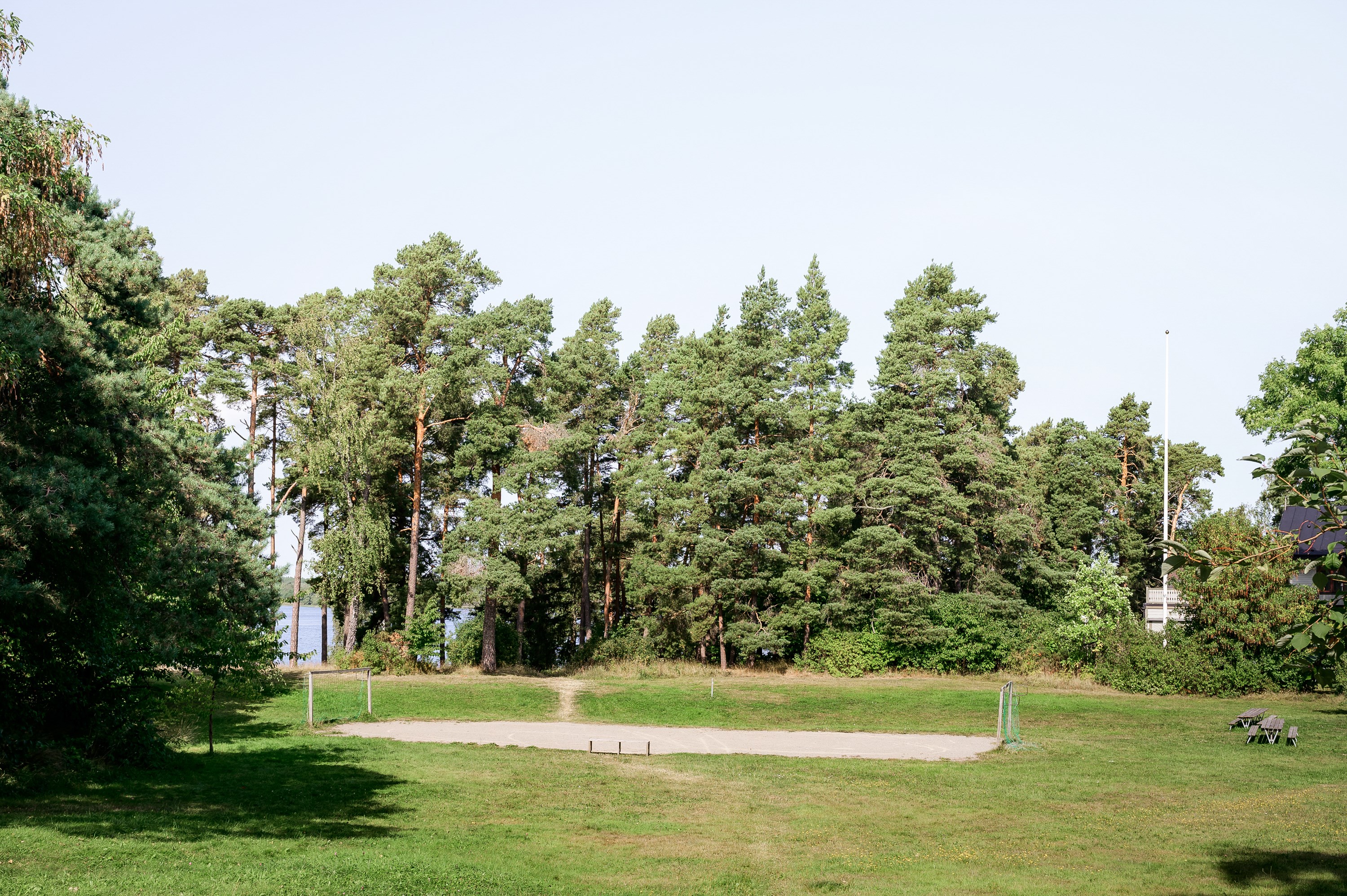 Husets altan gränsar till plana grönytor med promenadavstånd till badplats.