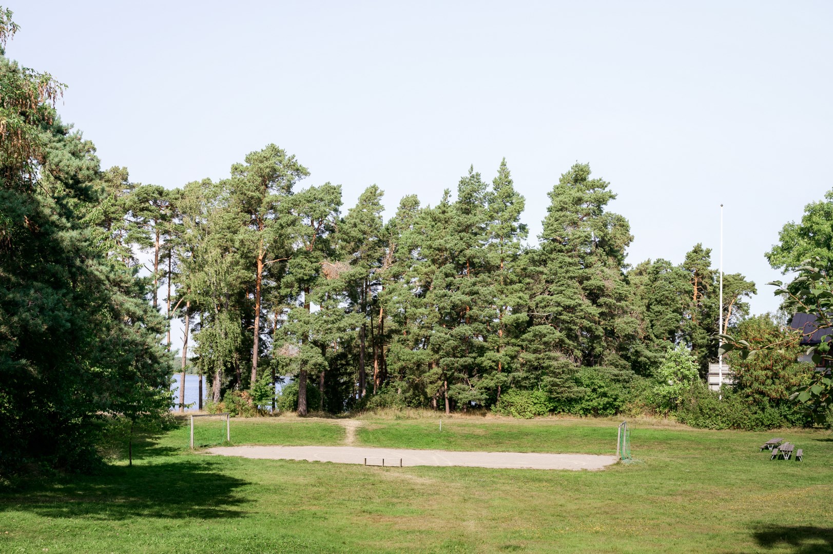 Husets altan gränsar till plana grönytor med promenadavstånd till badplats.
