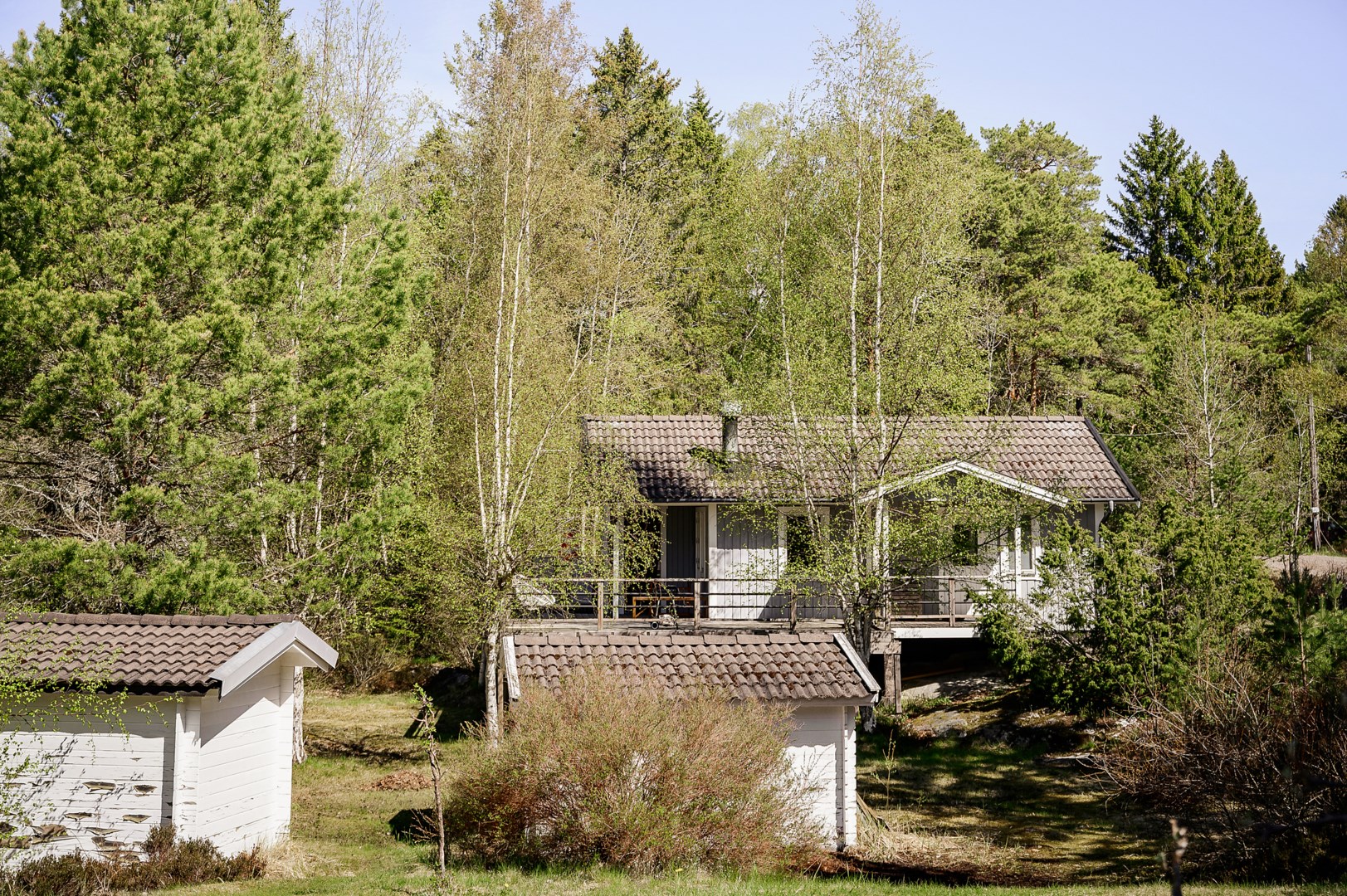 Vy från huvudhuset över tomten mot gästhuset