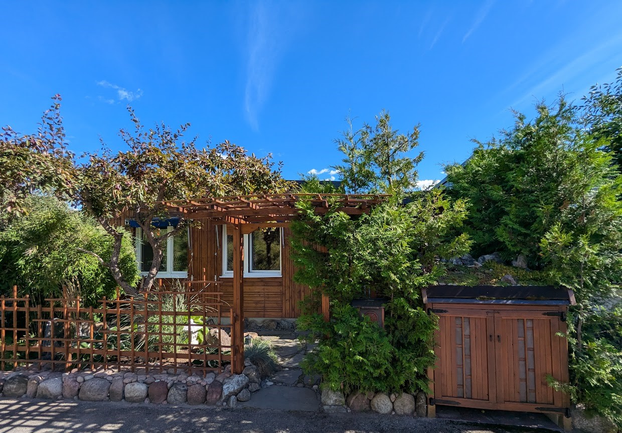 Husets västra entré. Garage och parkering återfinns ett stenkast från tomtgräns.