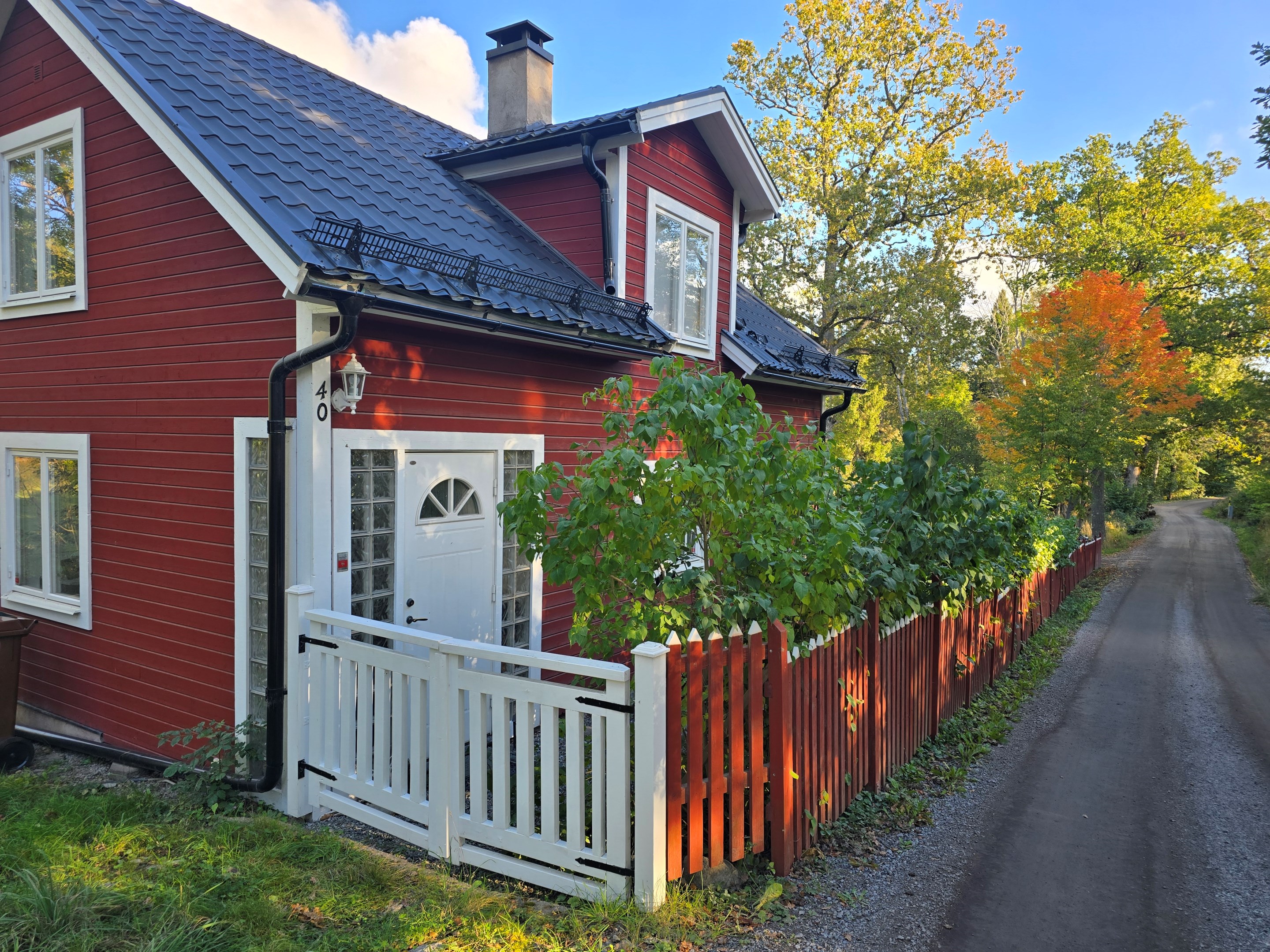Staket och den uppvuxna grönskan skärmar av insynen från vägen