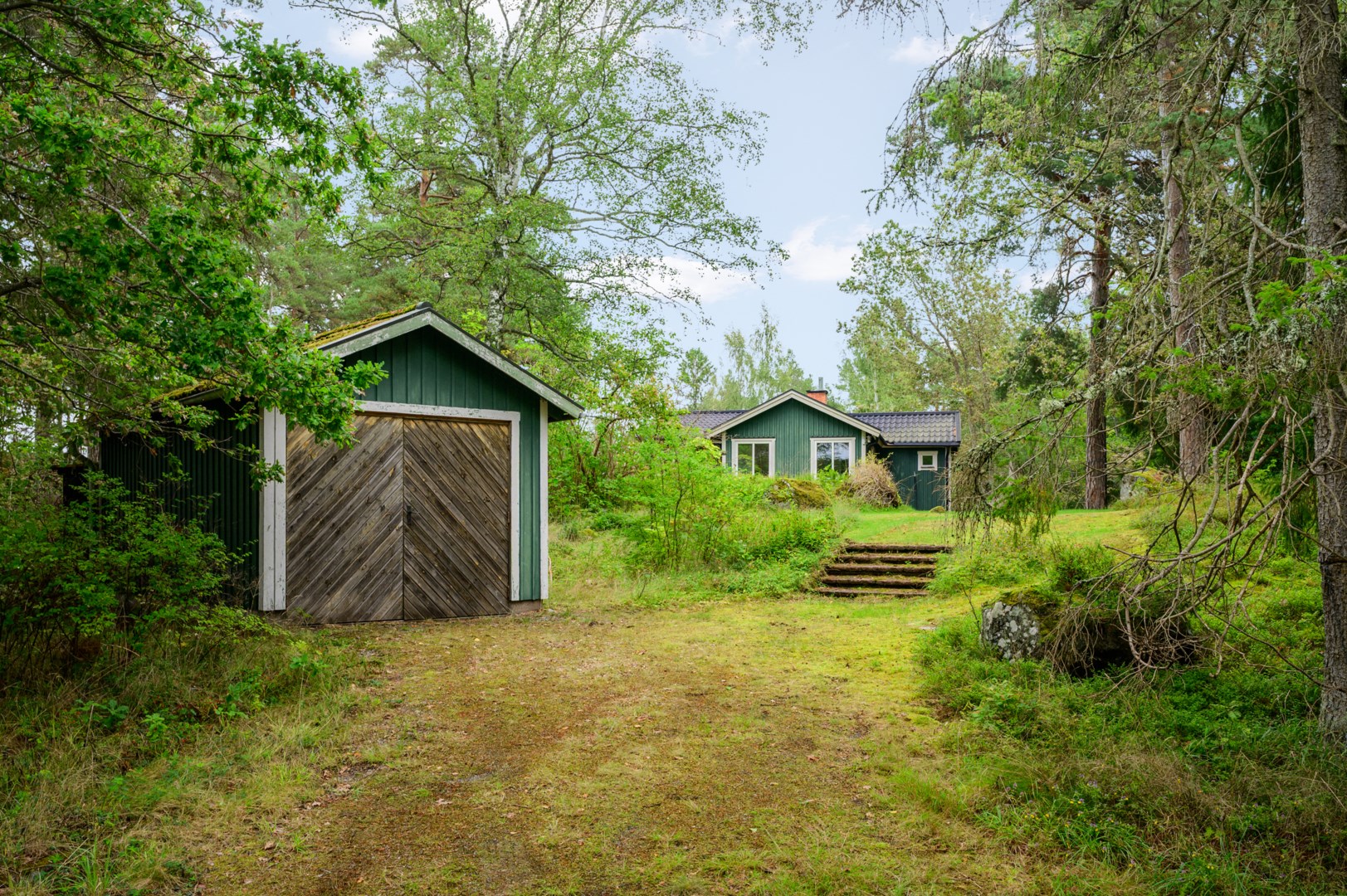 Egen infart med garage och förråd i anslutning till gästhuset.