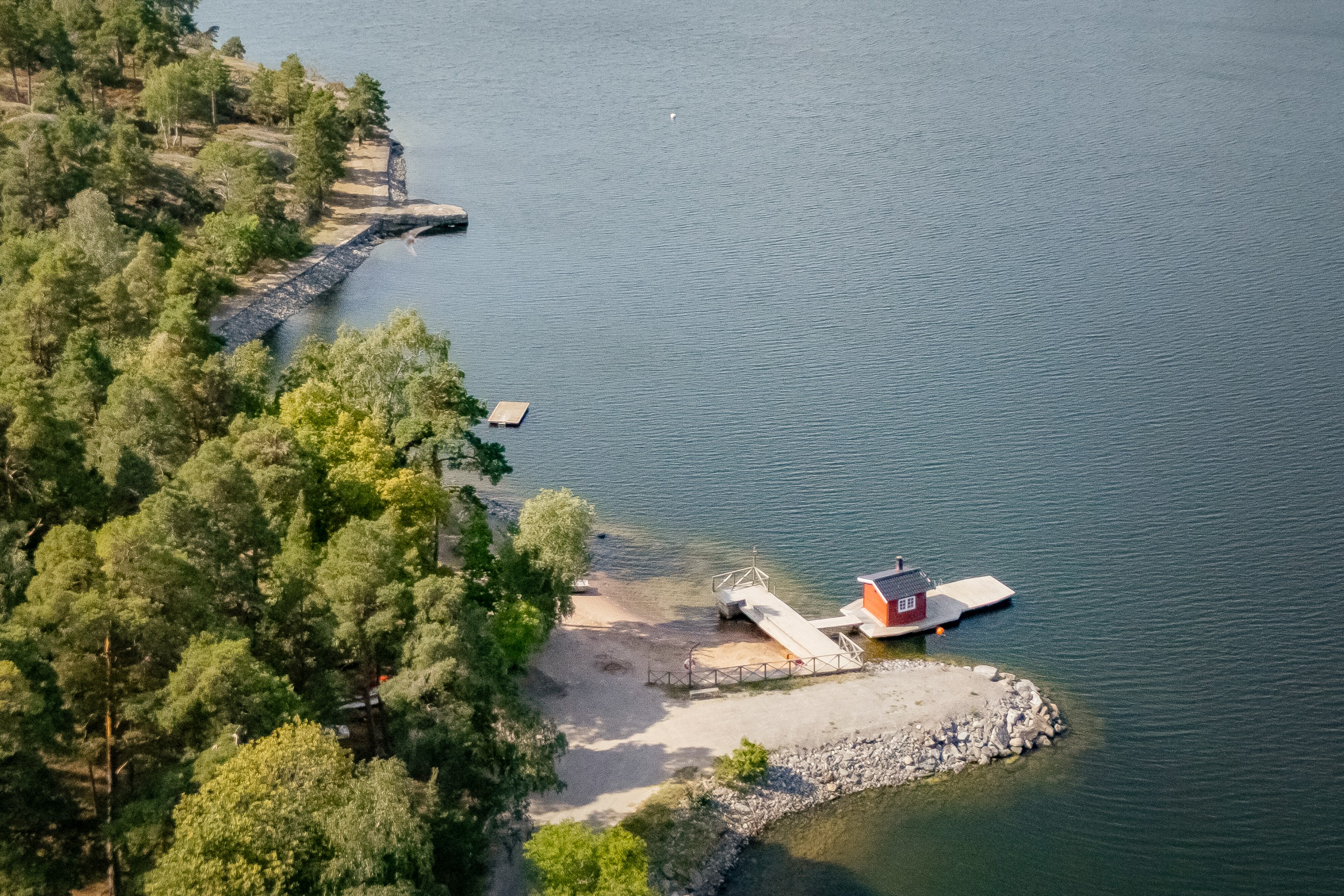 Områdets badstrand med bastuflotte.