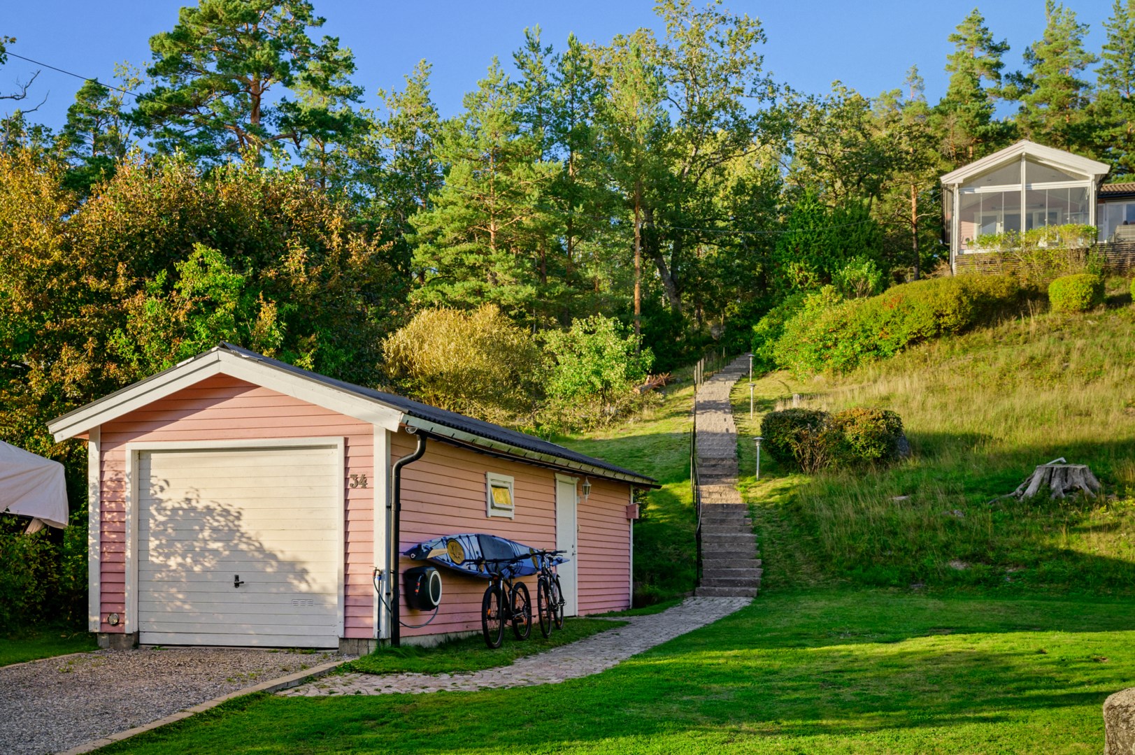Garage med anslutande förråd och laddstolpe för elbil.
