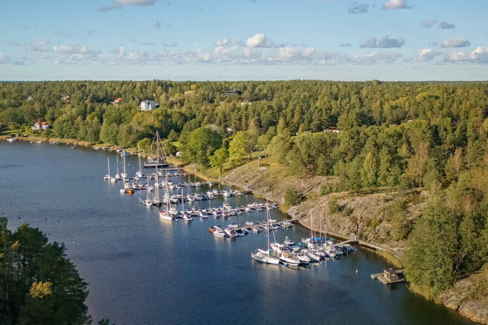 Värmdöviks båtklubb med bastu och klubbhus - huset skymtar mellan träden till höger i bild. 
