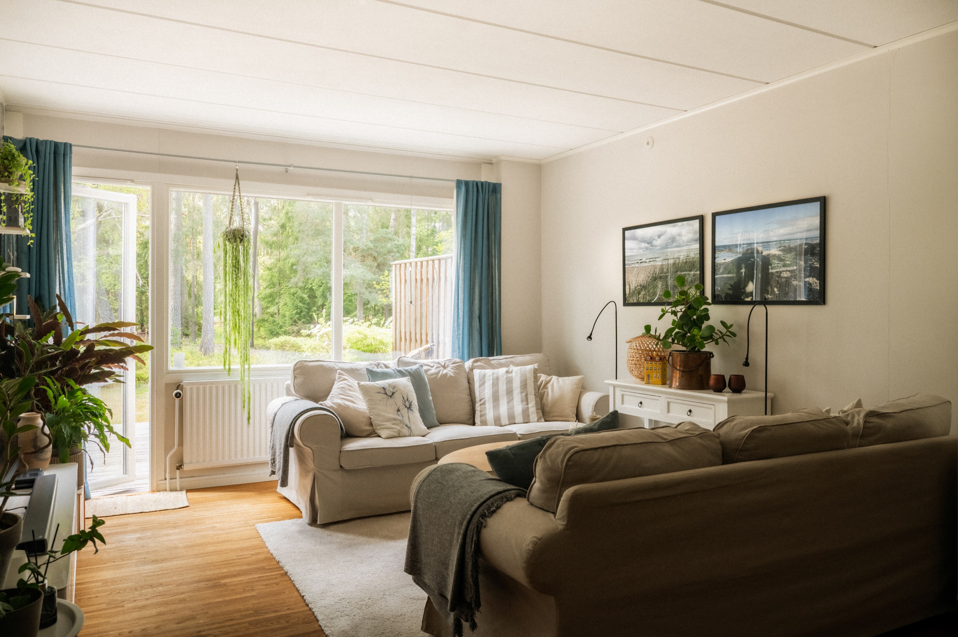 Vardagsrum med utgång till altan och trädgård med naturen som kuliss