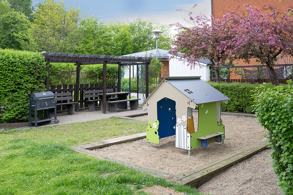 Gården med trevliga planteringar och pergola