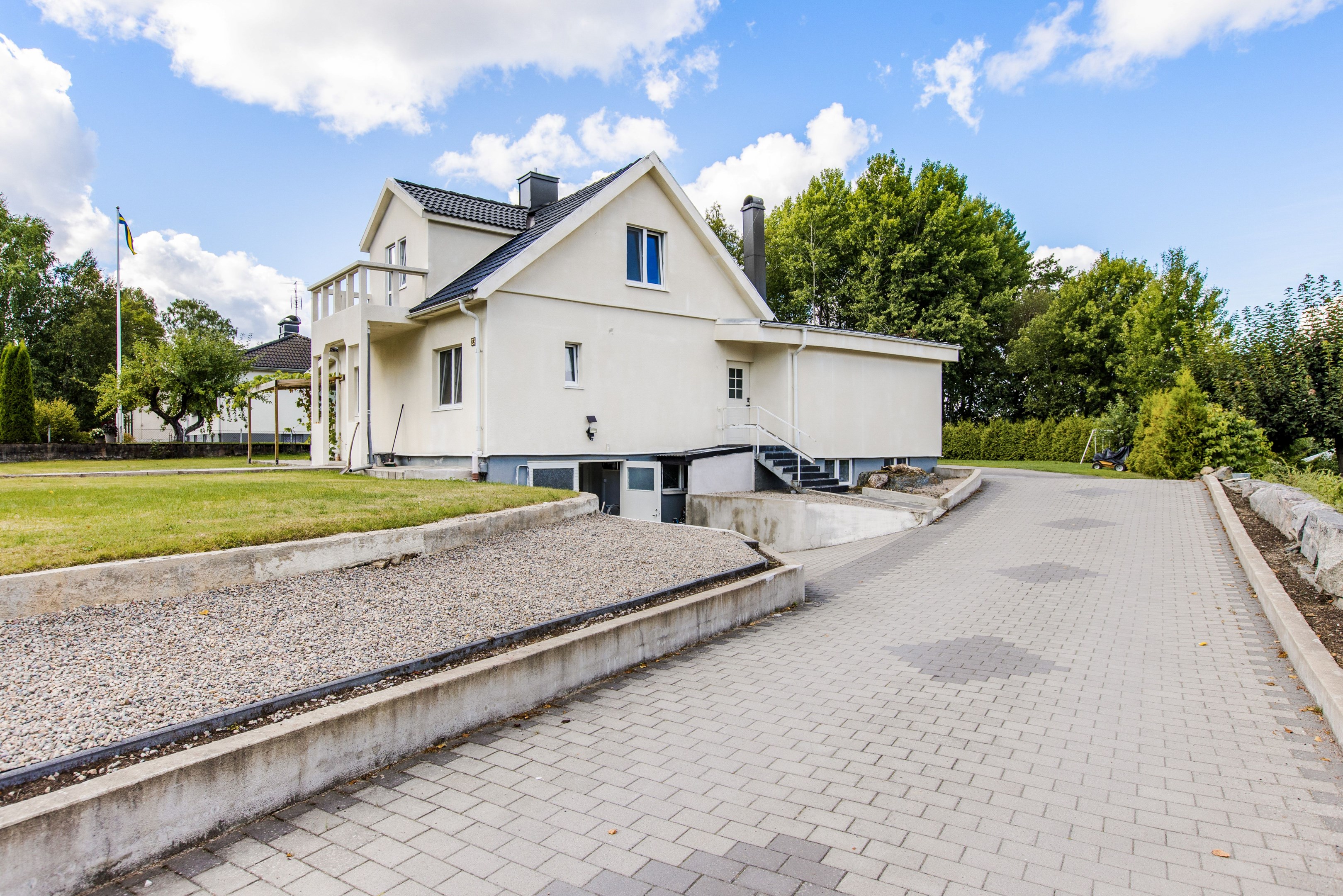 Sidobild med stenlagd infart till fastigheten