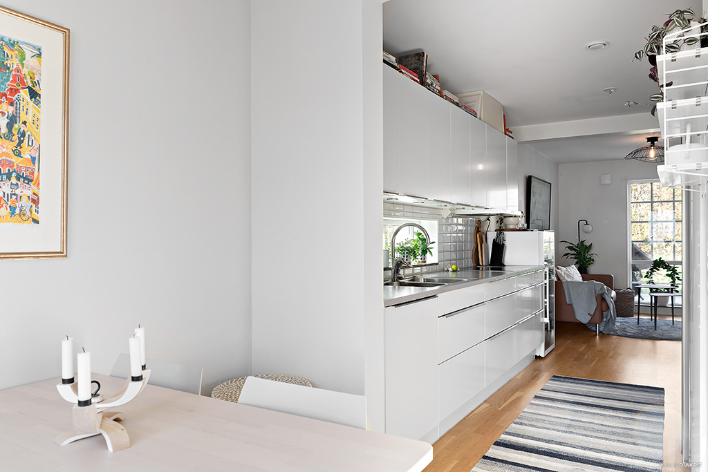 Köket med matplats och fint ljusinsläpp från fönster vid köksbänken