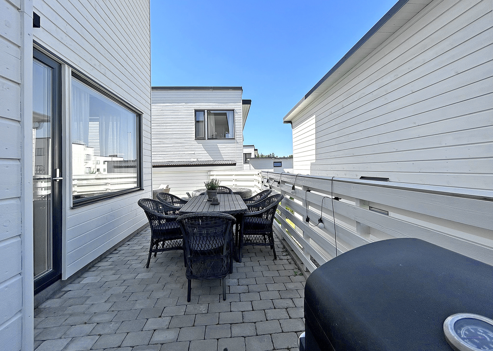 Tilltagen och stenbelagd uteplats i vinkel