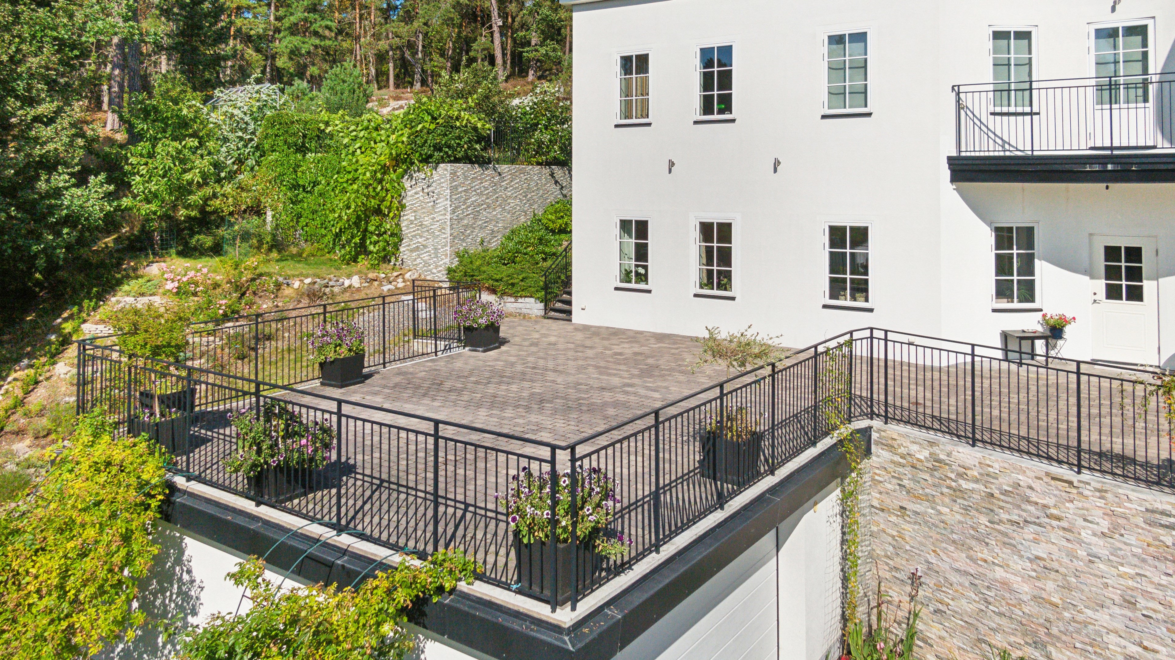 Stor solig stenlagd uteplats i soligt söderläge