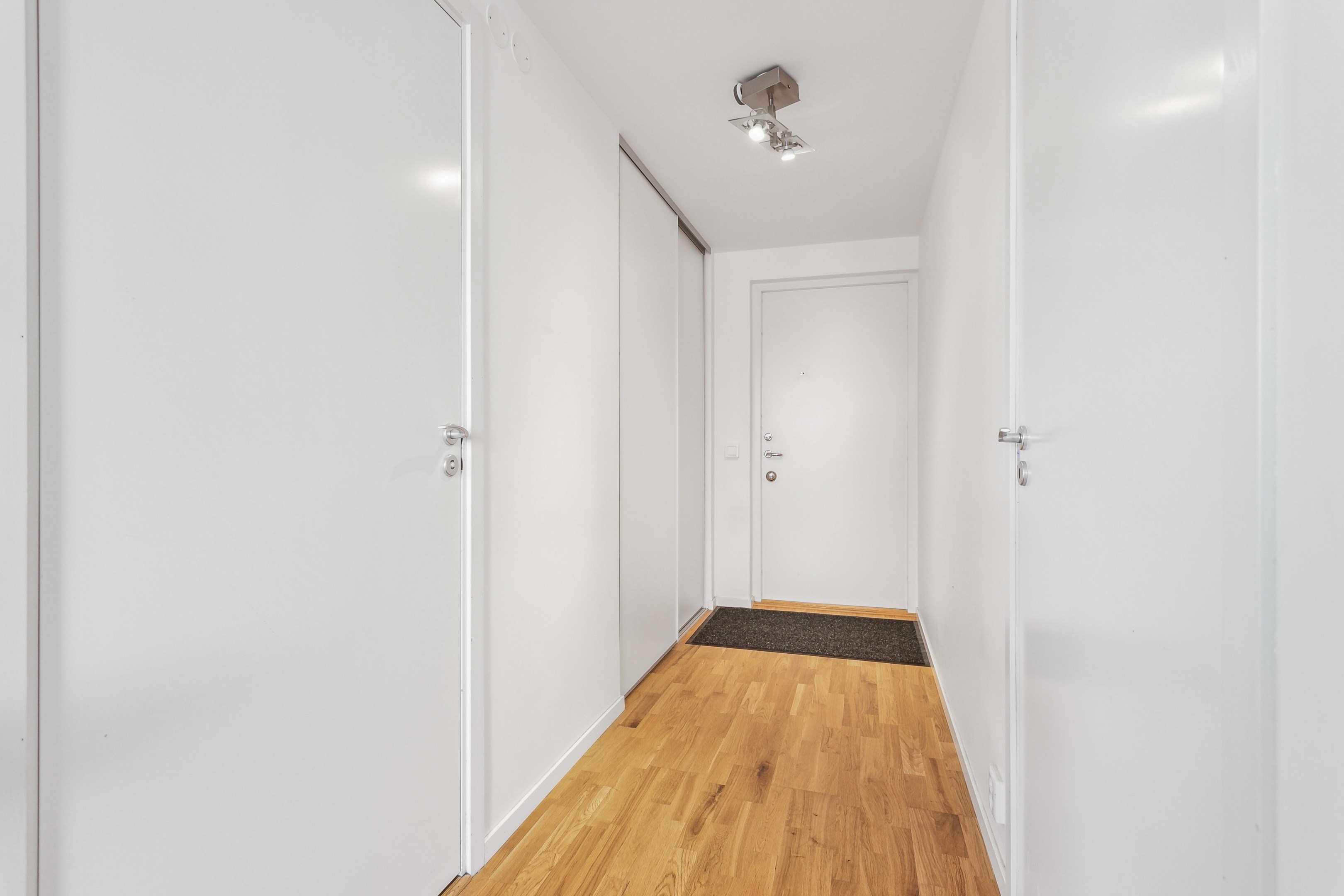 Praktisk hall med förvaring bakom två skjutdörrar