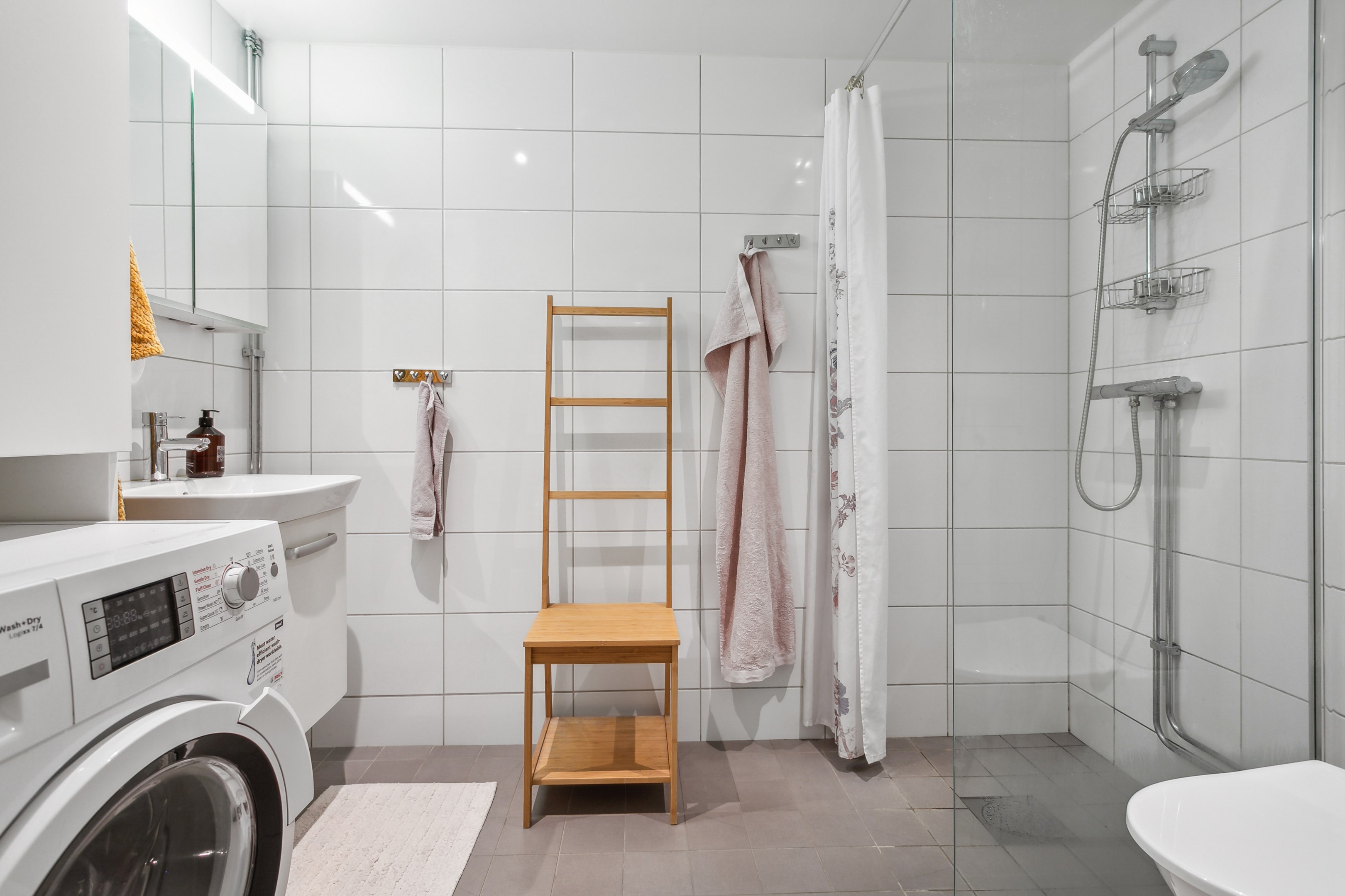 Helkaklad dusch/WC med tvättmaskin som har inbyggd torktumlare