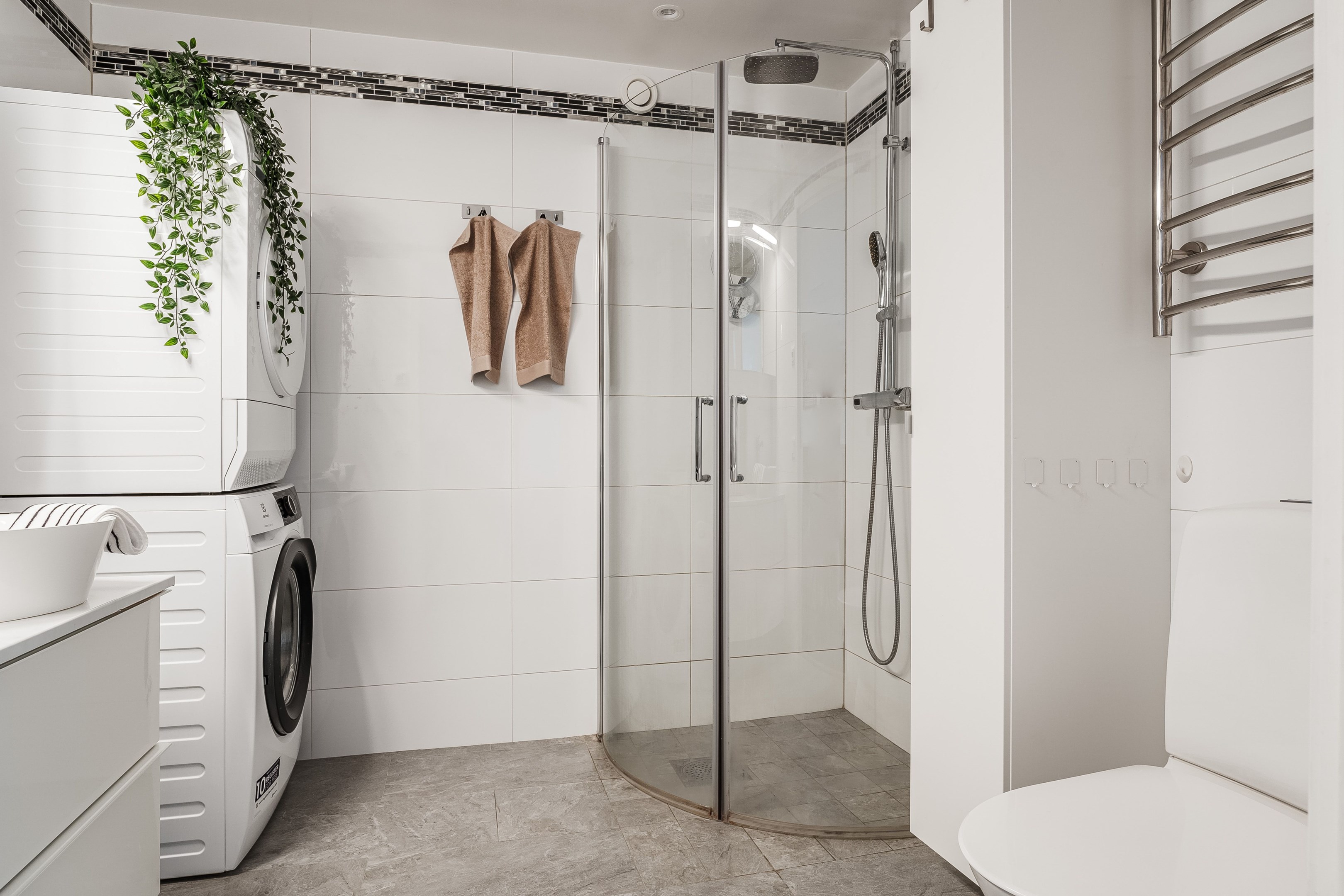 Våtrum med kakel och klinker, tvättpelare, duschhörna, handdukstork m.m.