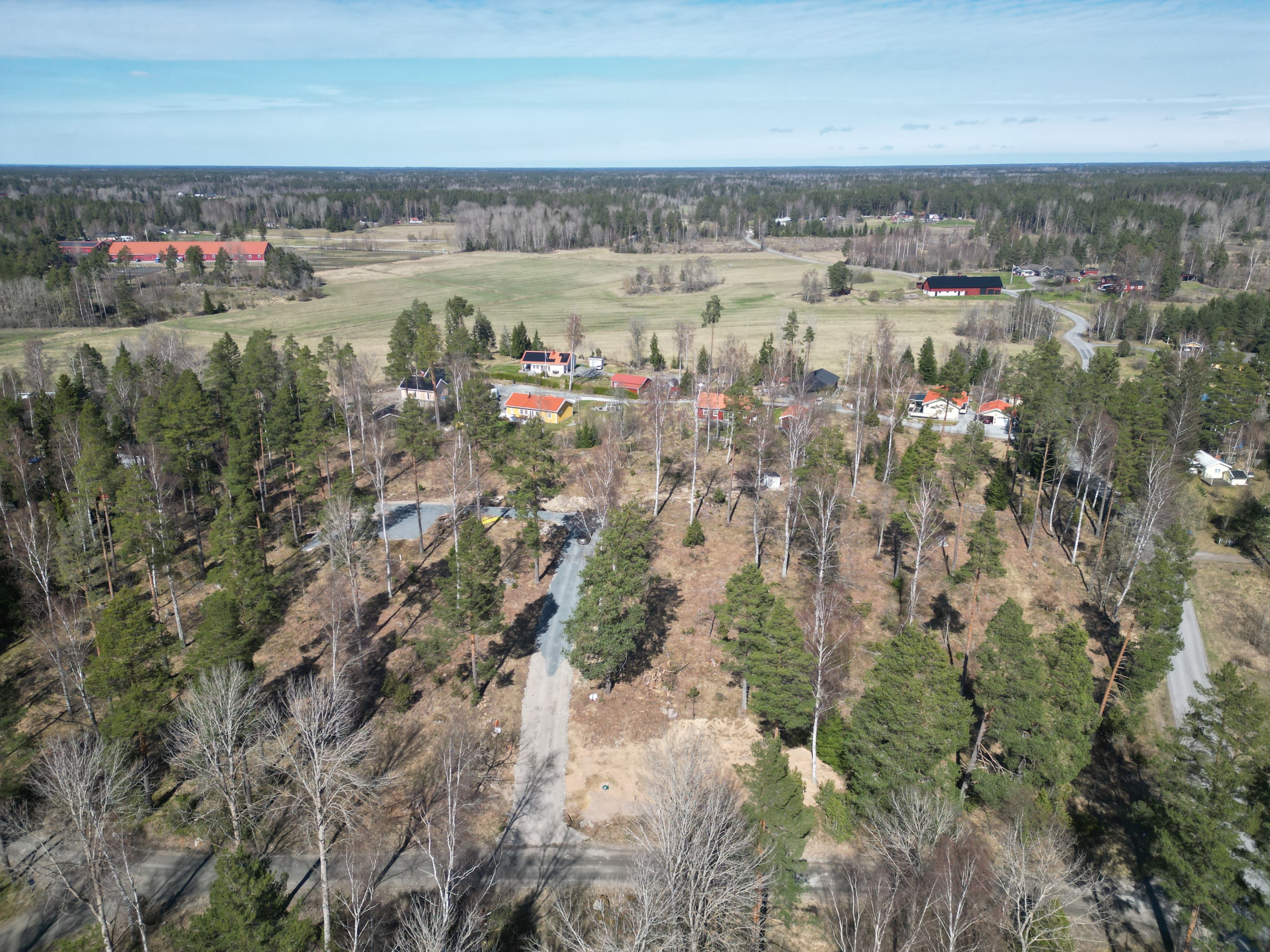 Drönarbild med omgivningar. Allmänn badplats och flera hästgårdar i närområdet