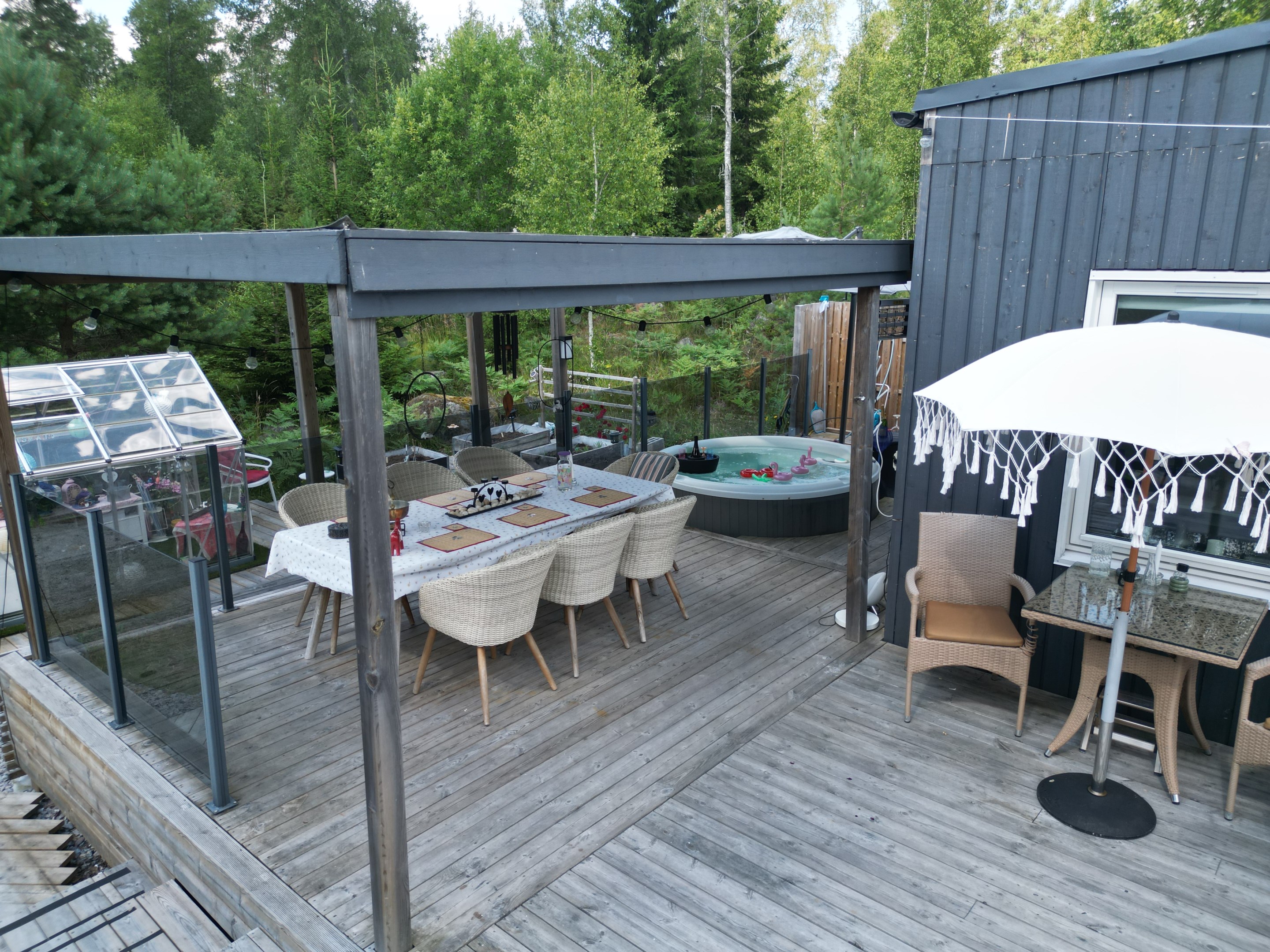 Altan under tak med matplats och spabad