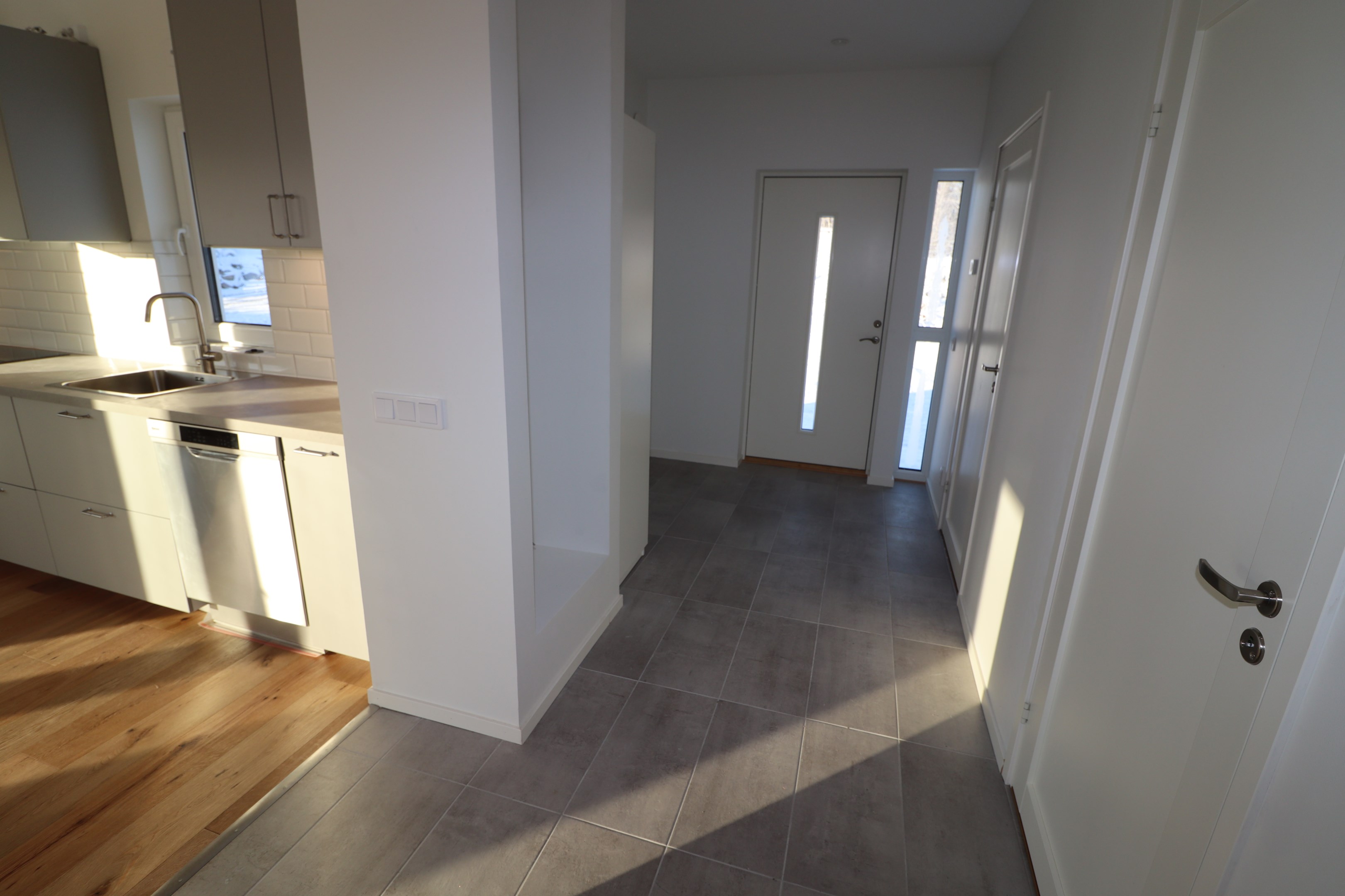 Hall med plats att hänga av kläder. Tvättstuga och badrum till höger