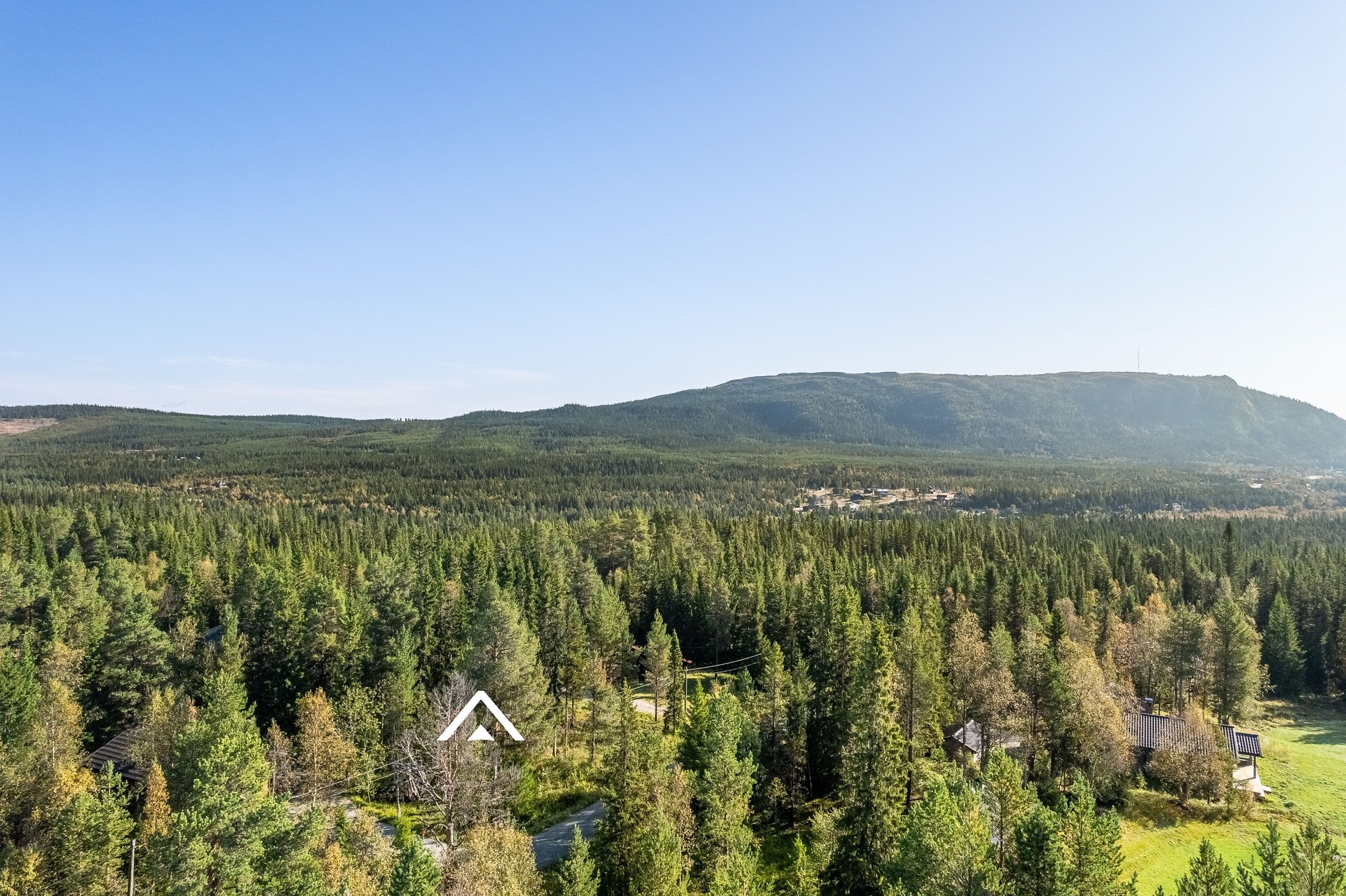 Tomten markerad med symbol. Funäsdalsberget i bakgrunden