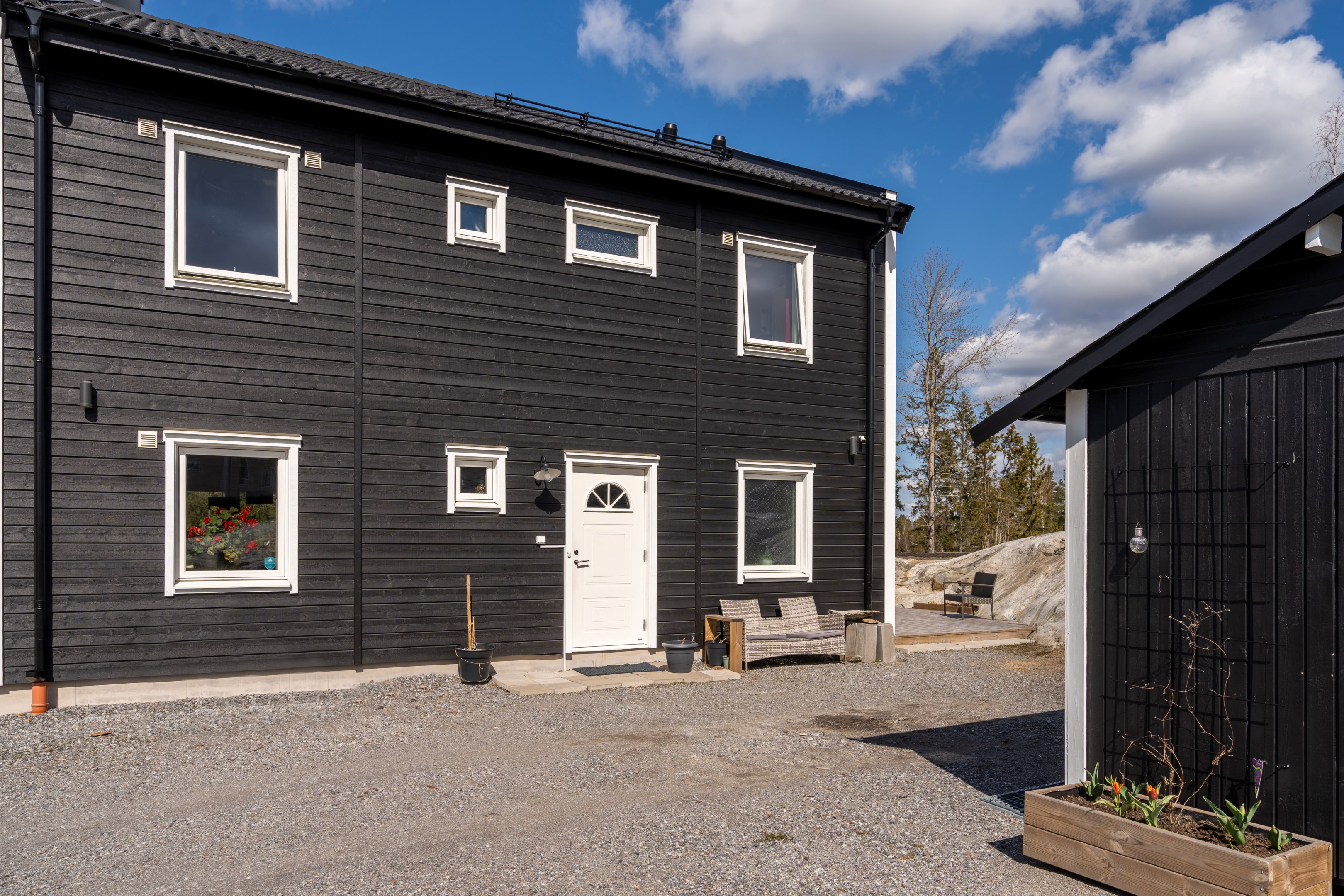 Entré sida med fristående förråd