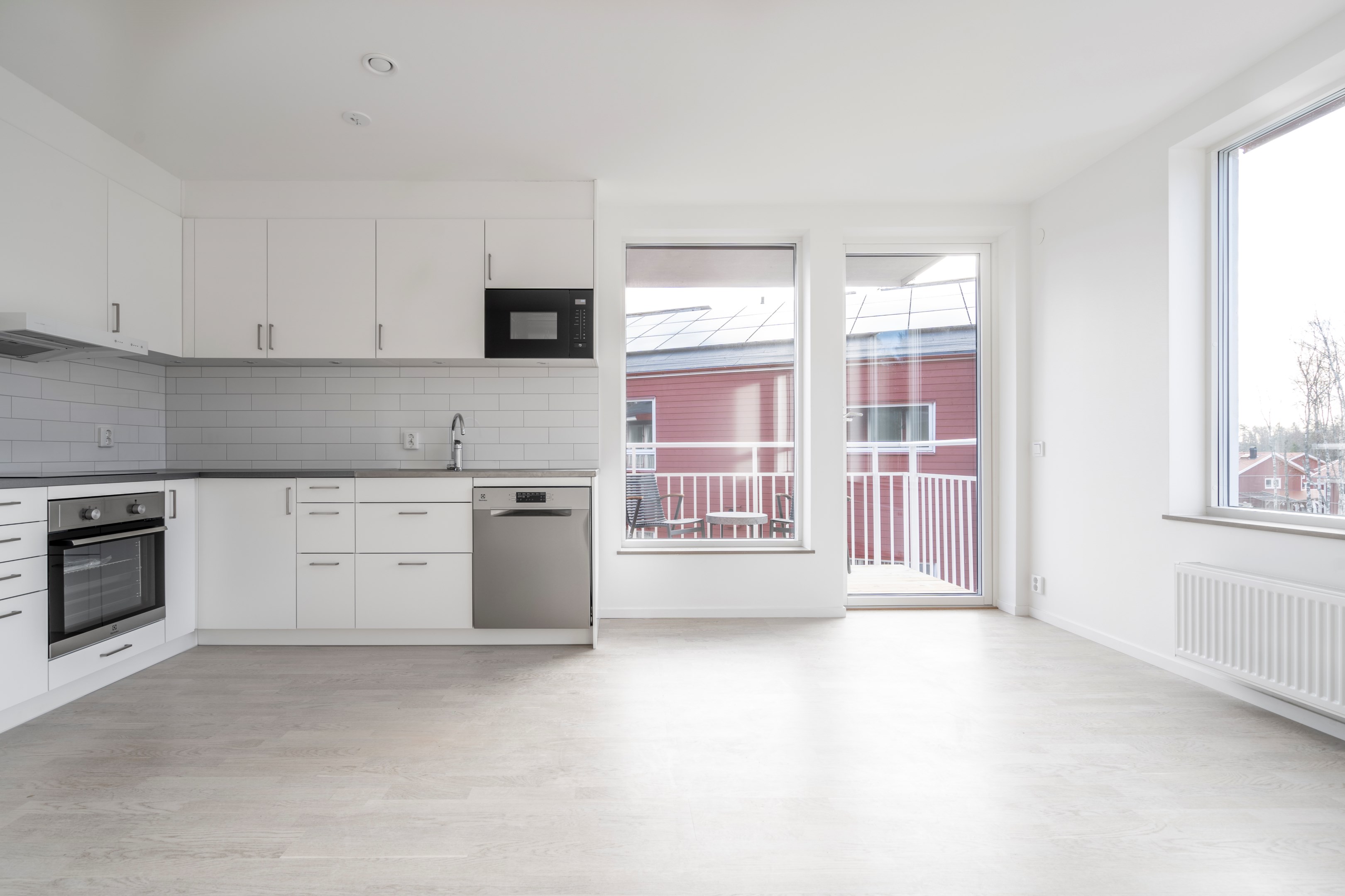 Kök med plats för matbord vid fönster. Utgång till balkong