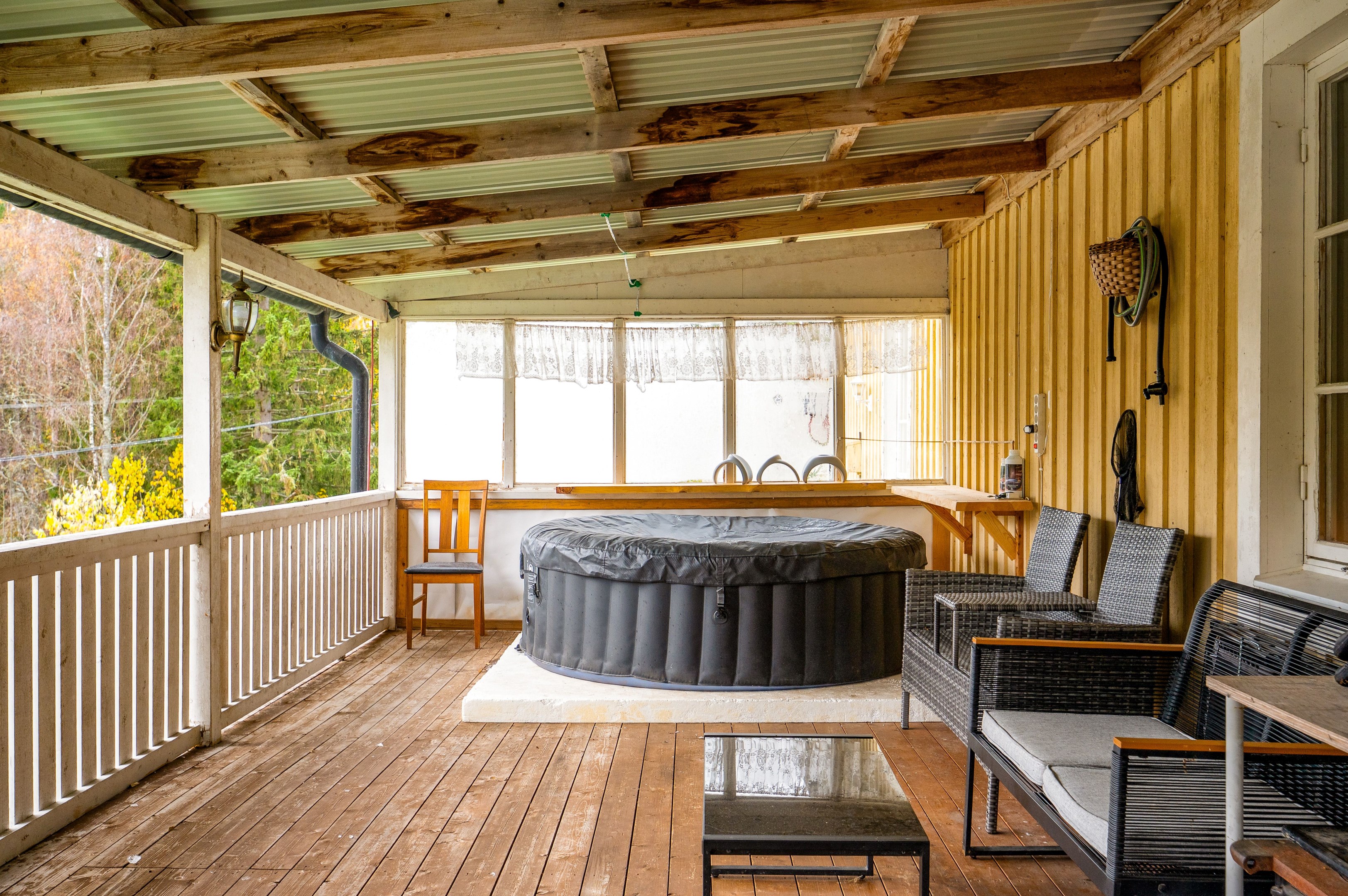 Stor altan som går i vinkel runt halva huset