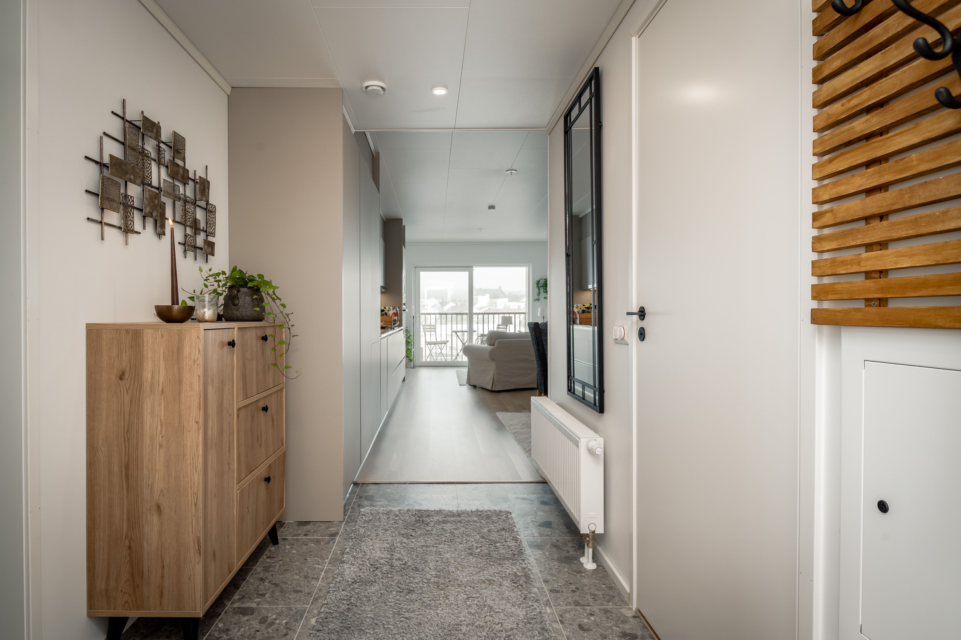 Ljus hall med klinker som öppnar upp mot lägenheten