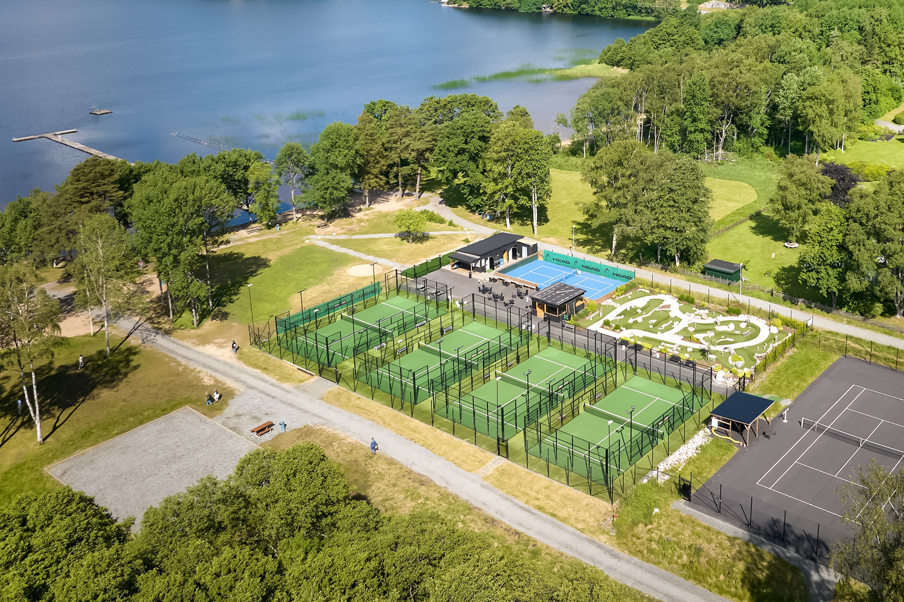 Sandstrand och bryggor med äventyrsgolf, paddel, tennis, pickleball och glasskafé