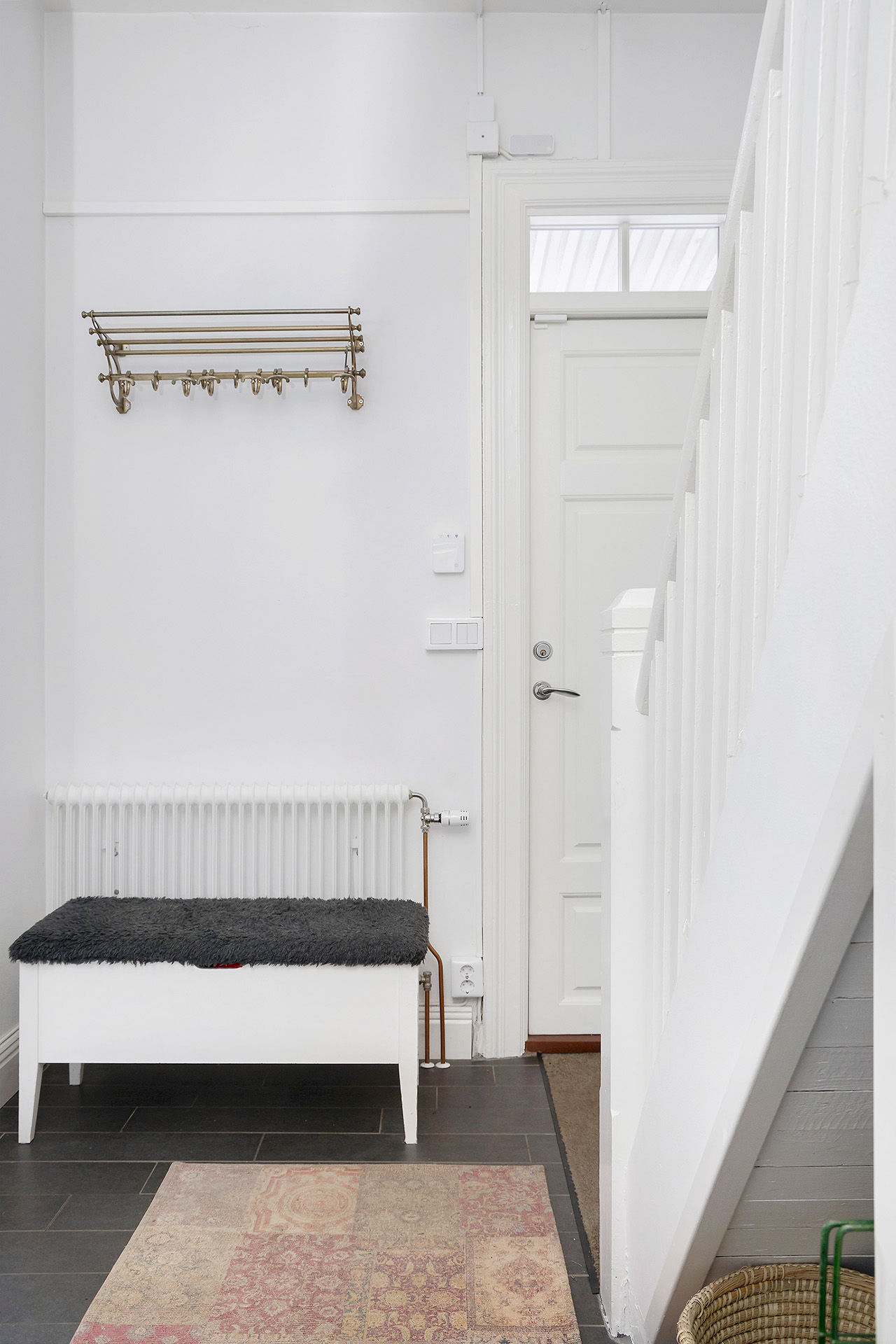 Hall med klinker och trappa till ovanvåning