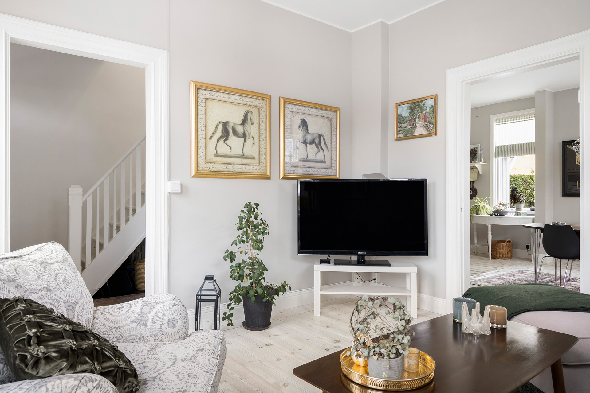 Vardagsrum med vy mot hall och kök